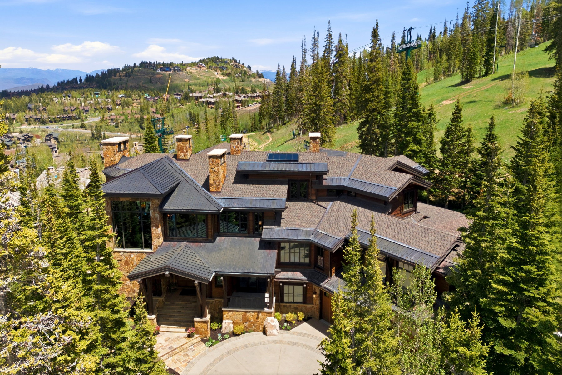 Hillside property featuring a stone and wood exterior with multiple gables
