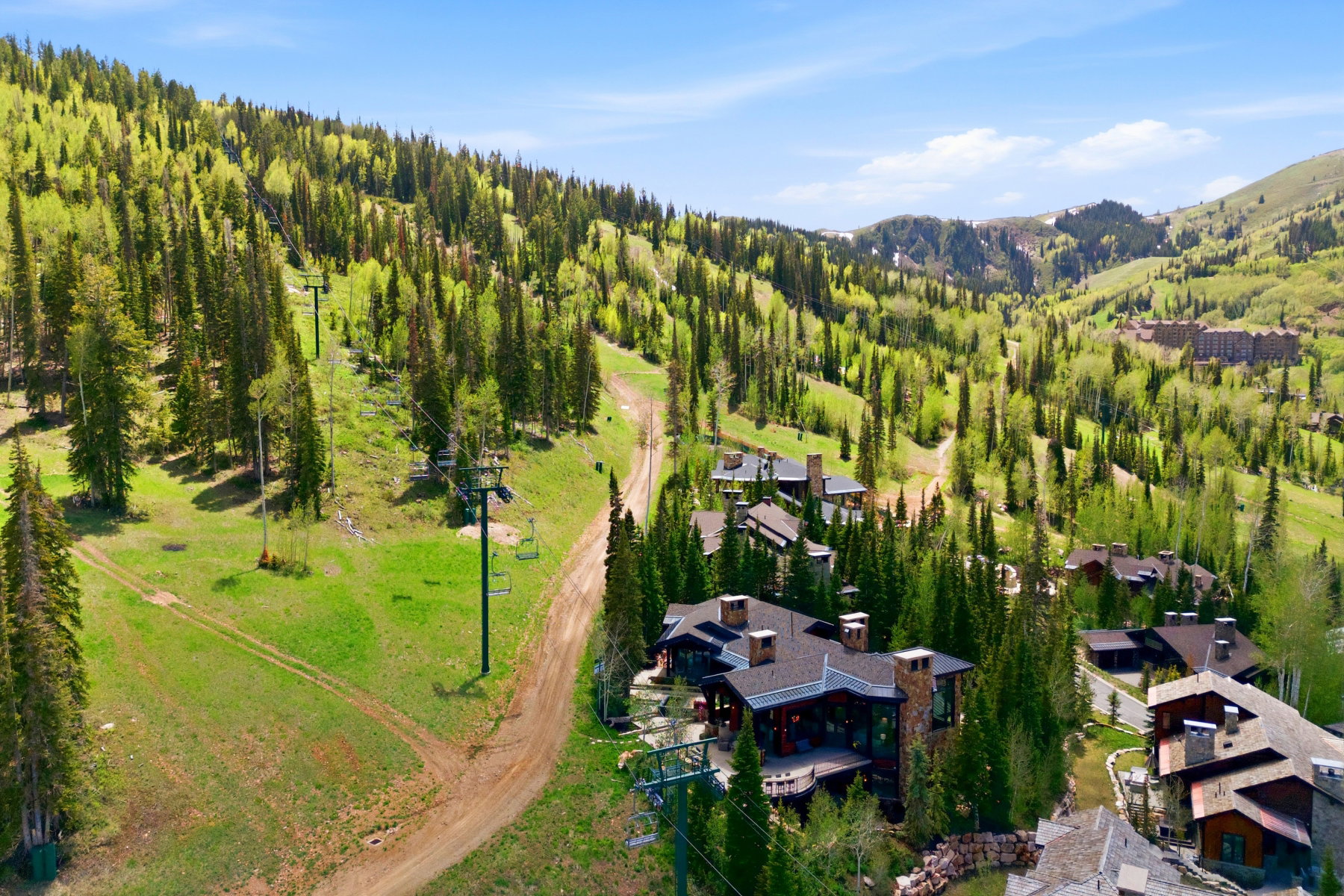 Mountain property featuring a stone and wood exterior, multiple chimneys, and a spacious deck