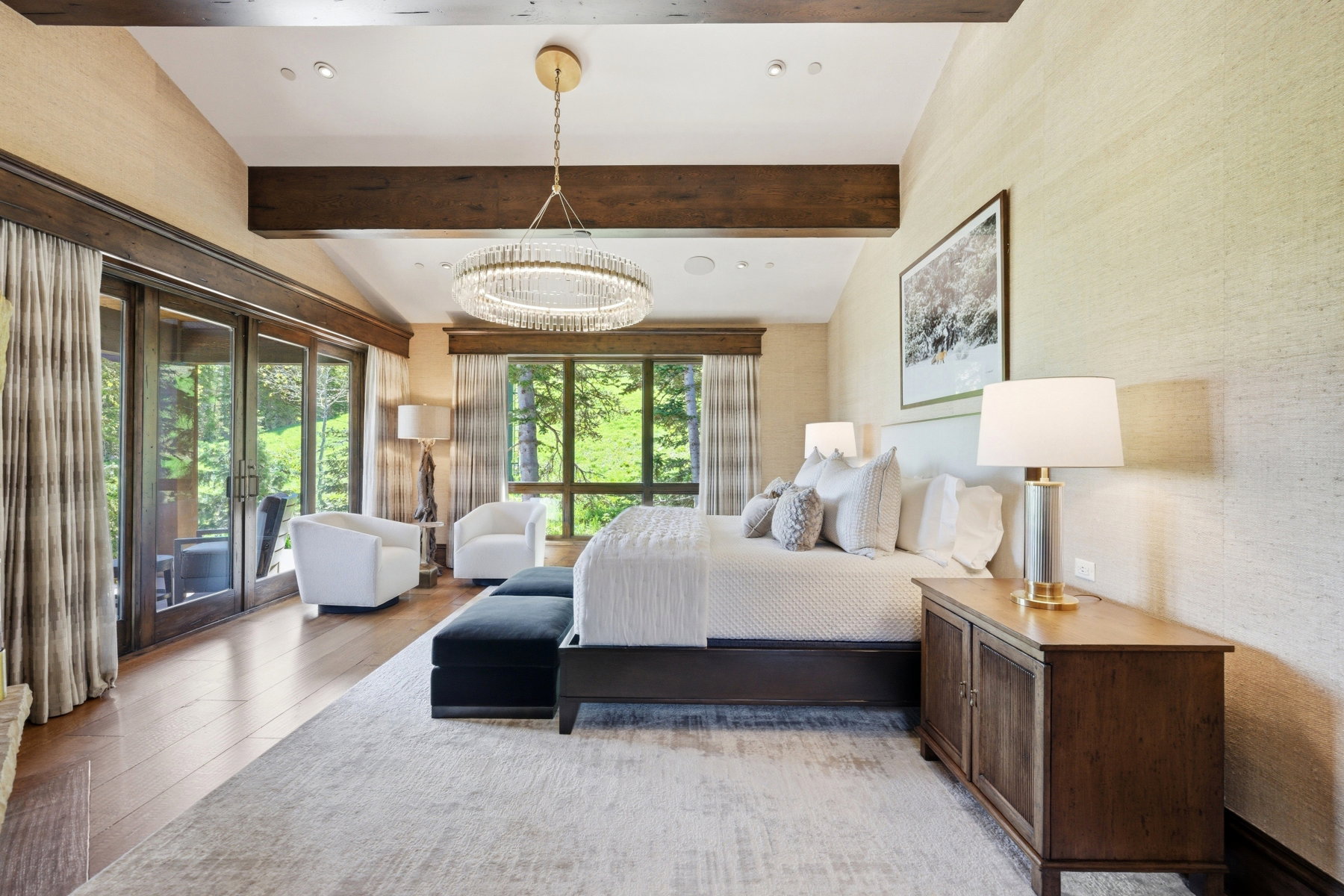 Vaulted ceiling with exposed wood beams, wood-finish flooring, and direct outdoor access through glass panel doors