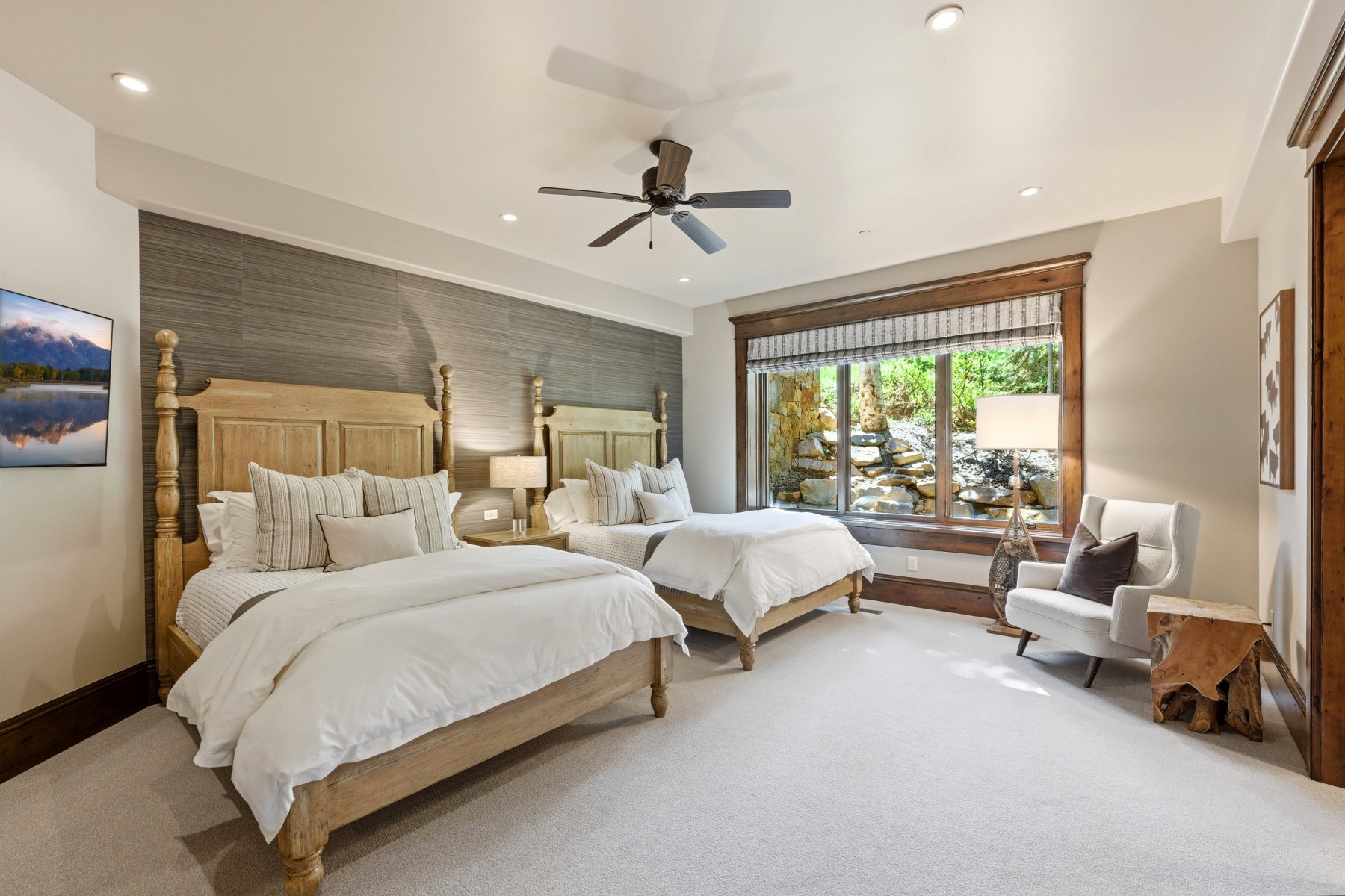 Carpeted room featuring a large window with exterior rock landscaping