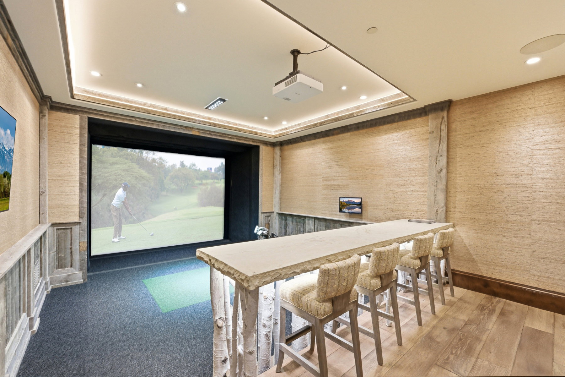 Dedicated golf simulator room featuring a large projection screen and dark gray carpet flooring