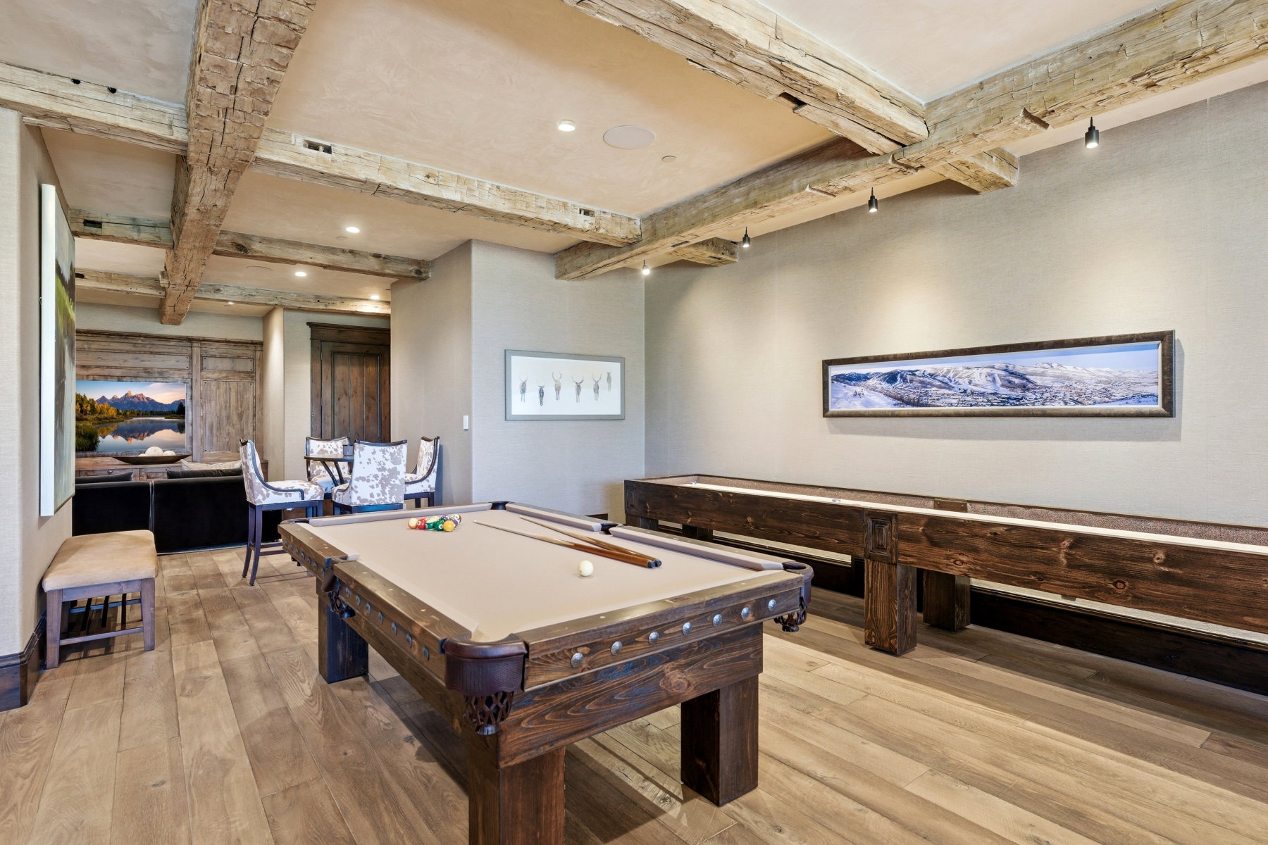 Reclaimed wood ceiling beams complement wide plank wood-finish flooring