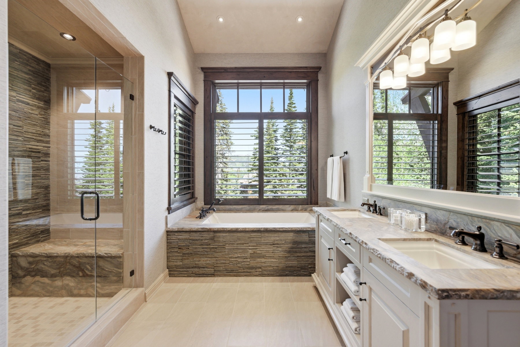Spacious bathroom featuring a glass-enclosed shower with integrated bench seating and tiled walls