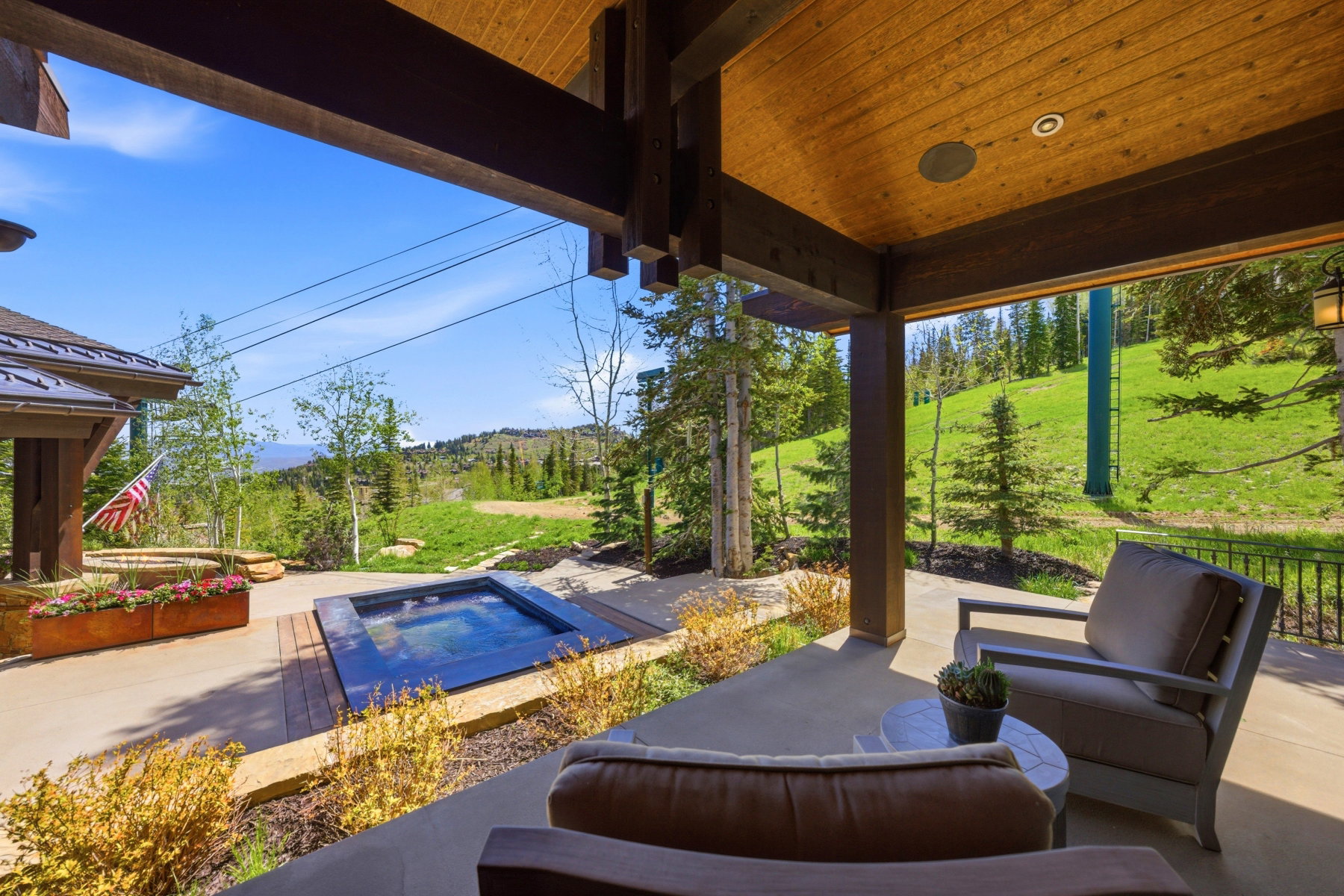 Covered outdoor patio featuring a wood-panel ceiling, exposed beams, and integrated lighting
