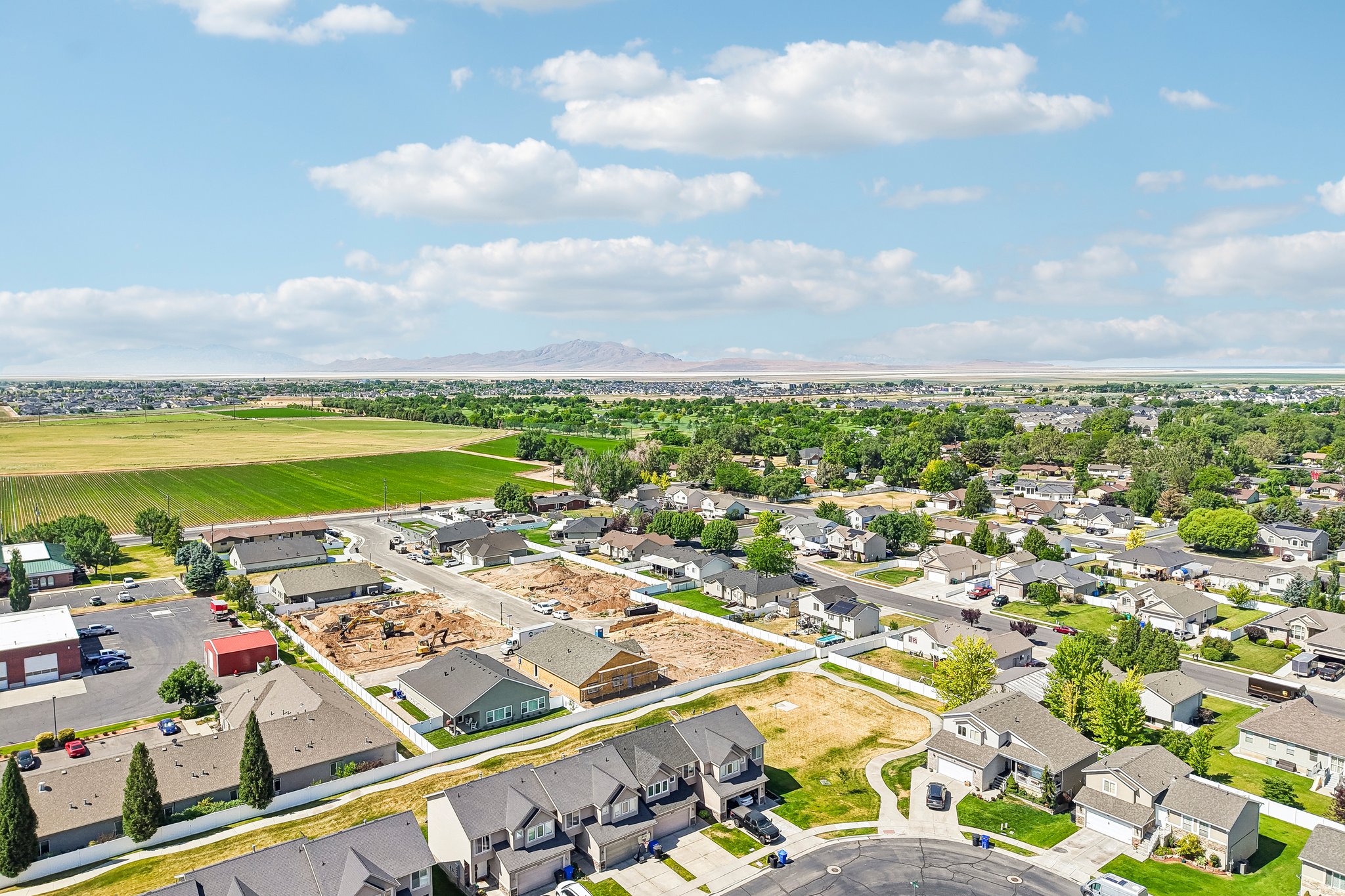 Aerial perspective showcasing a residential community with established homes, new construction, and undeveloped lots