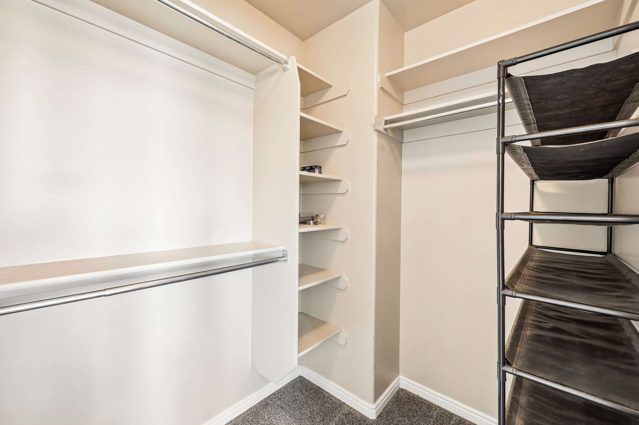 Spacious closet featuring multiple hanging rods, built-in shelving, and neutral wall paint