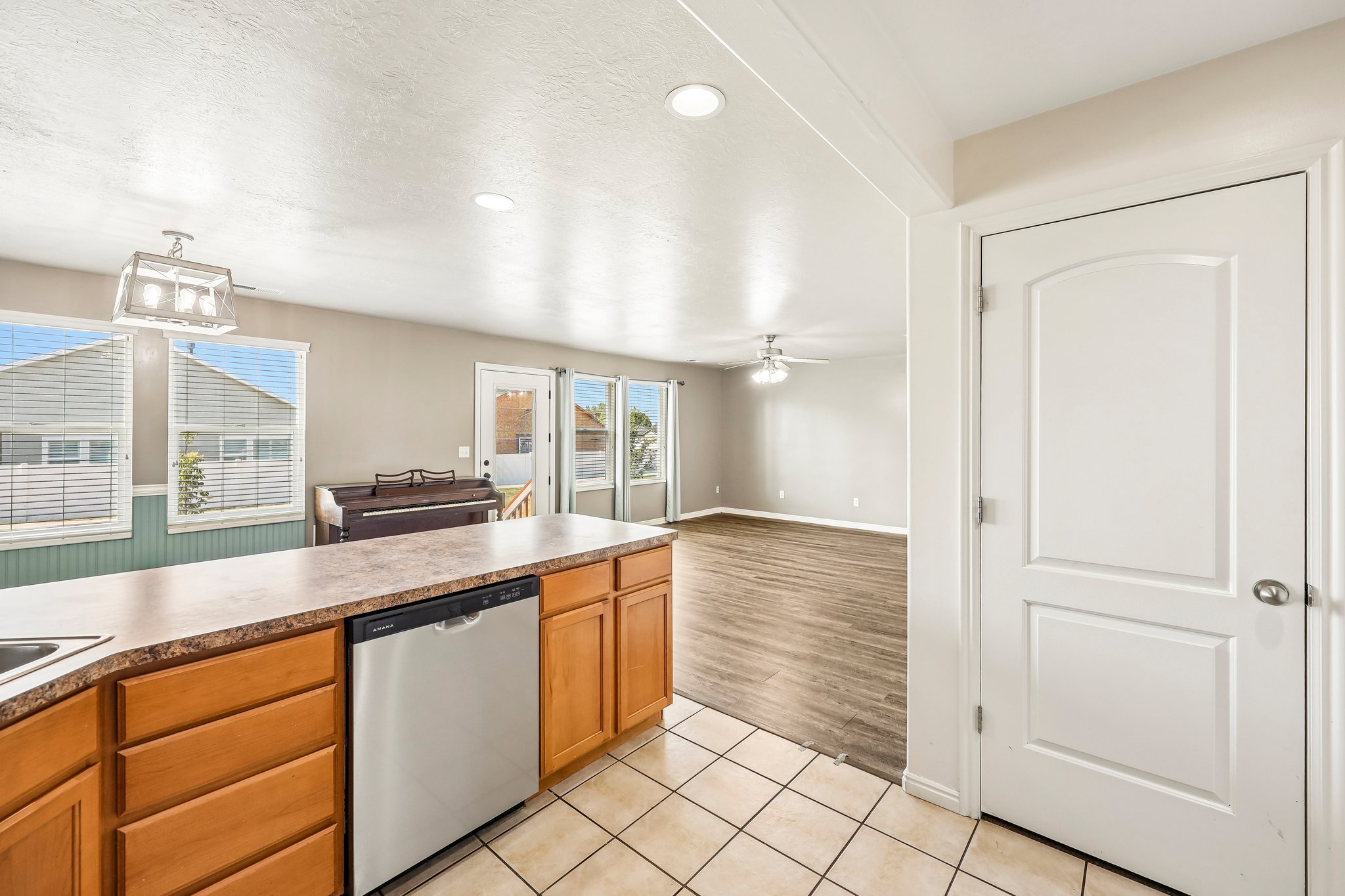 Kitchen island with wood cabinetry, stainless steel dishwasher, and laminate countertop