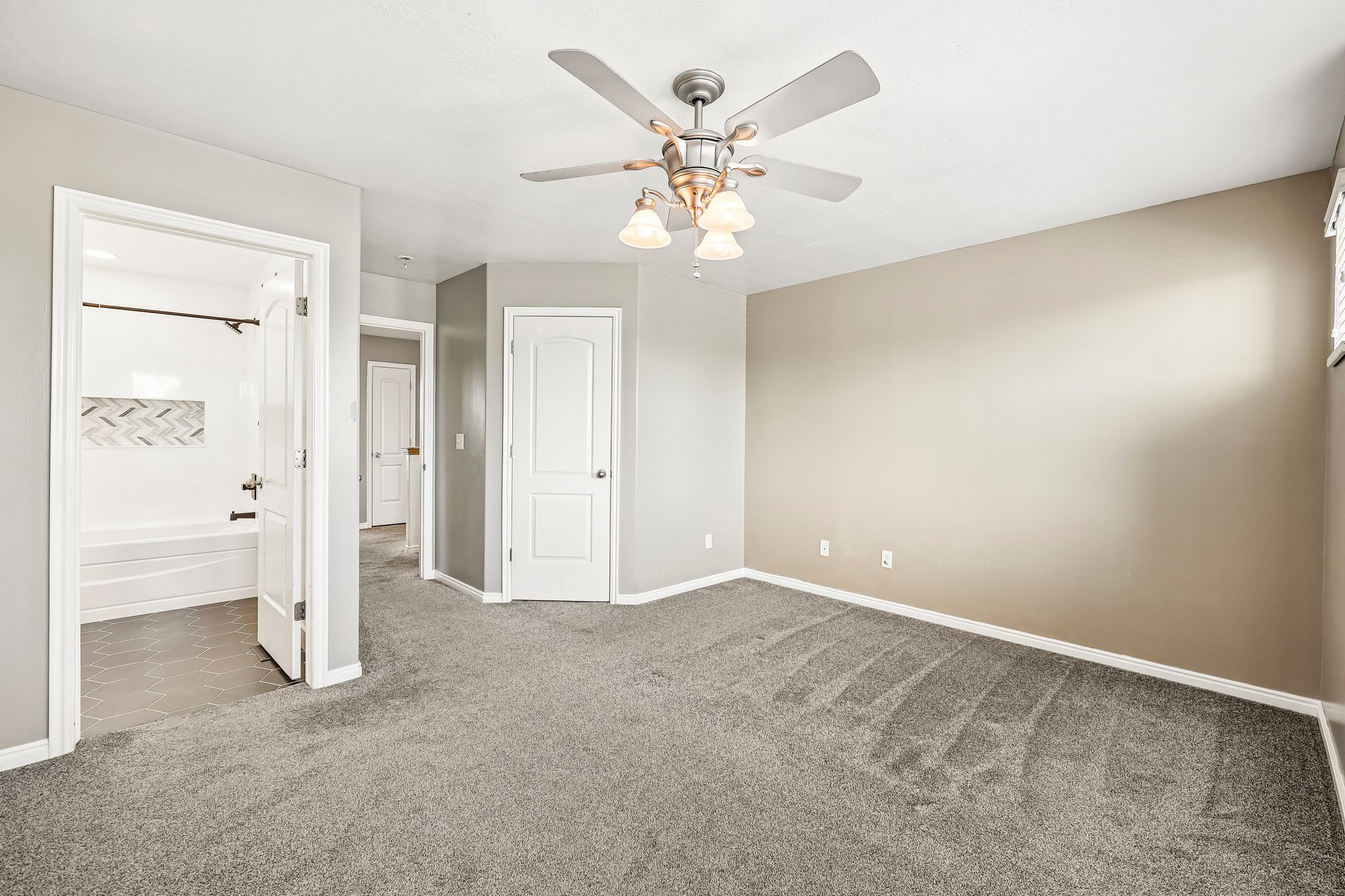 Spacious room with gray carpeting and light-toned walls