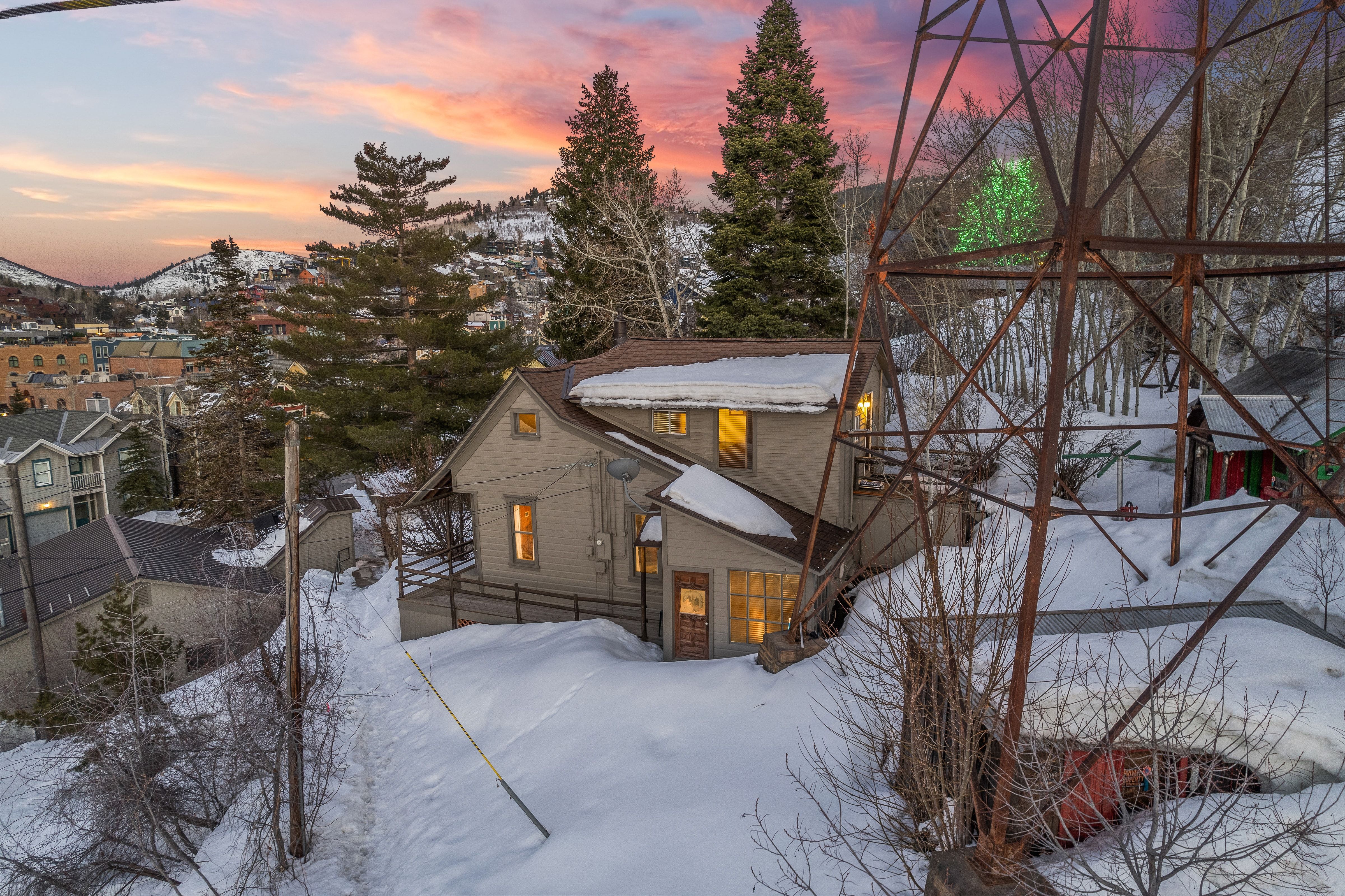 Two-story residence featuring a neutral-toned exterior, multiple windows, and a multi-pitch roofline