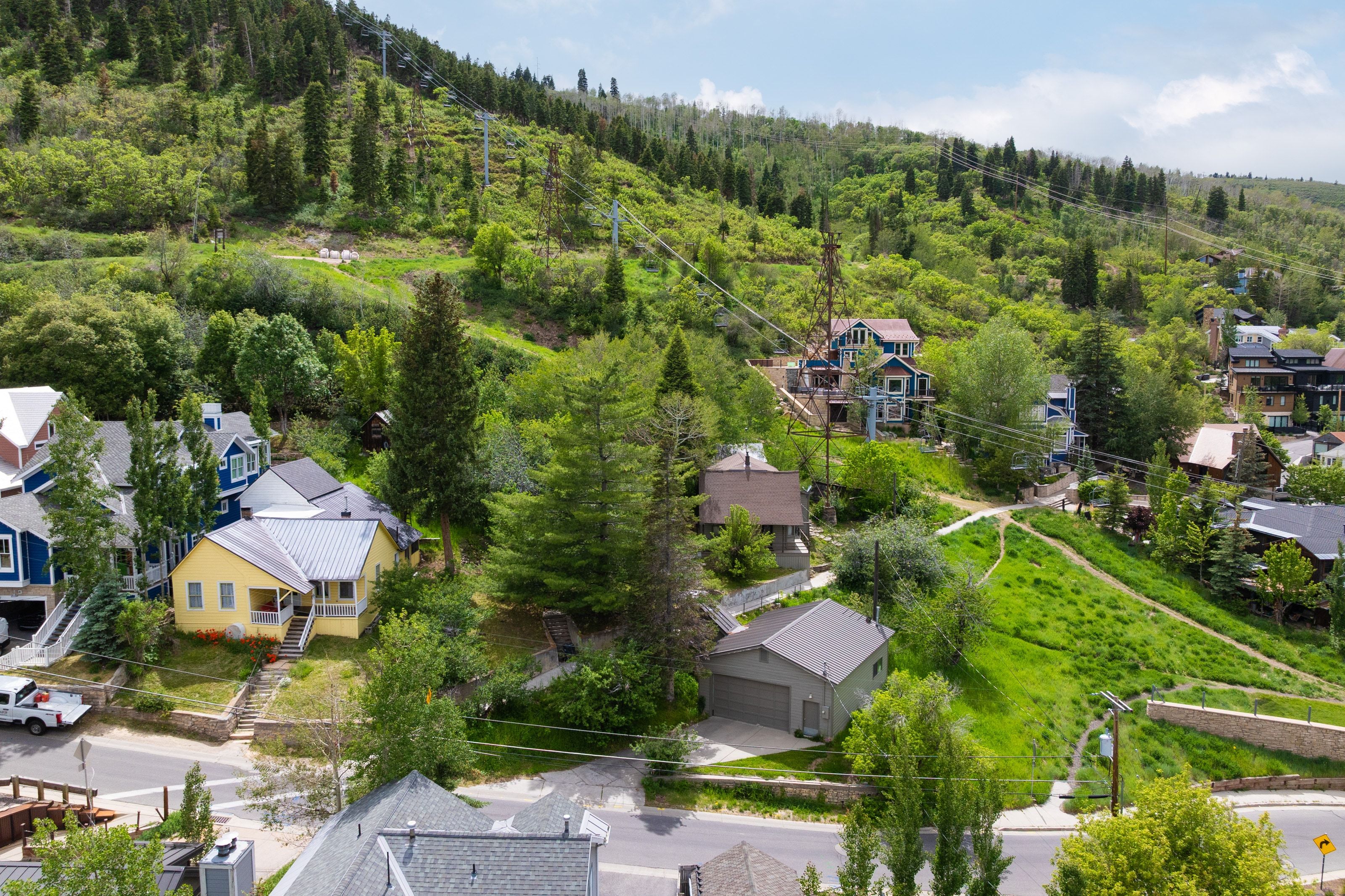 Neighborhood setting featuring diverse architectural styles, abundant mature trees, and varying topography
