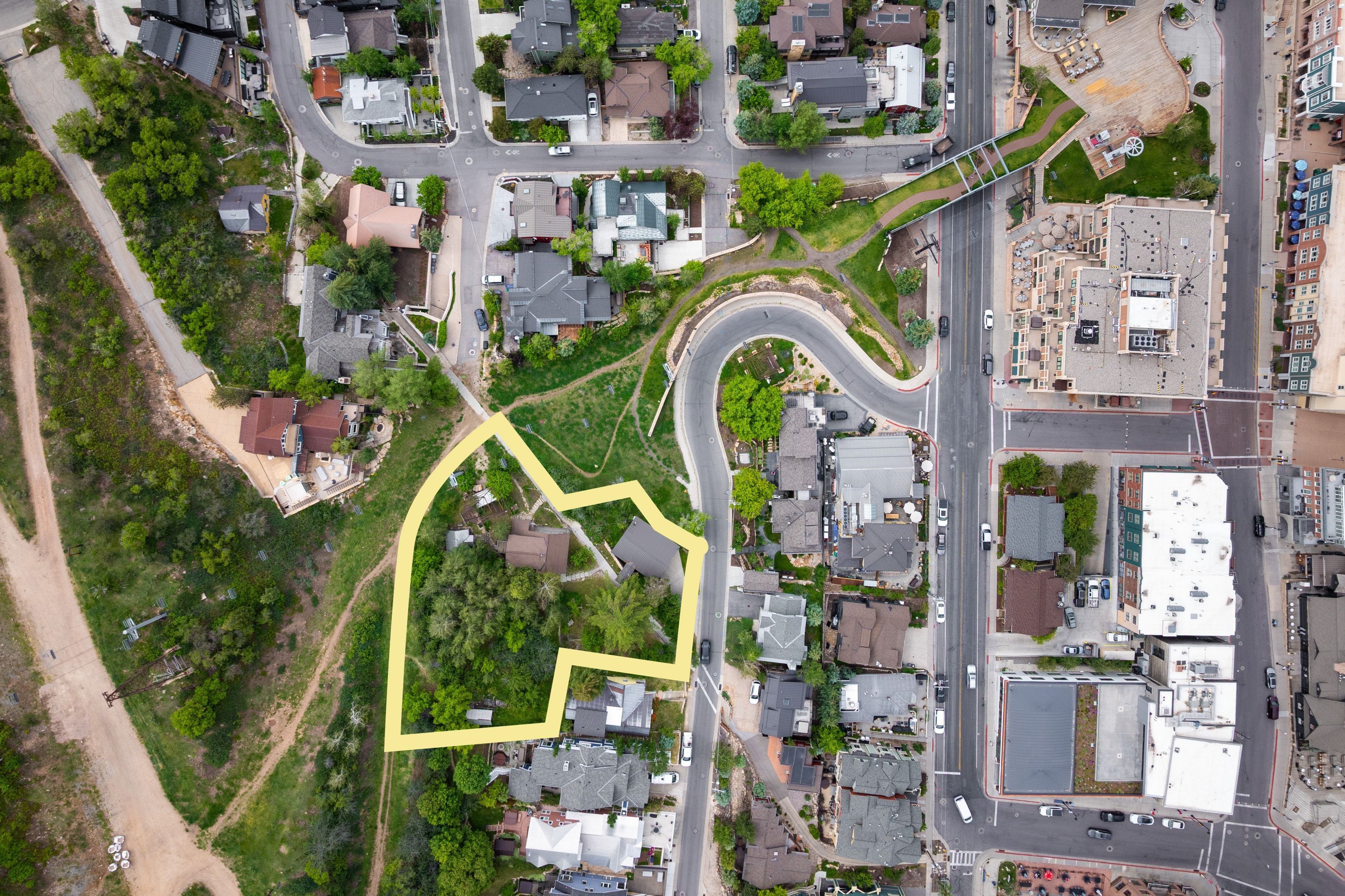 Expansive lot outlined in yellow, featuring mature trees and established residences