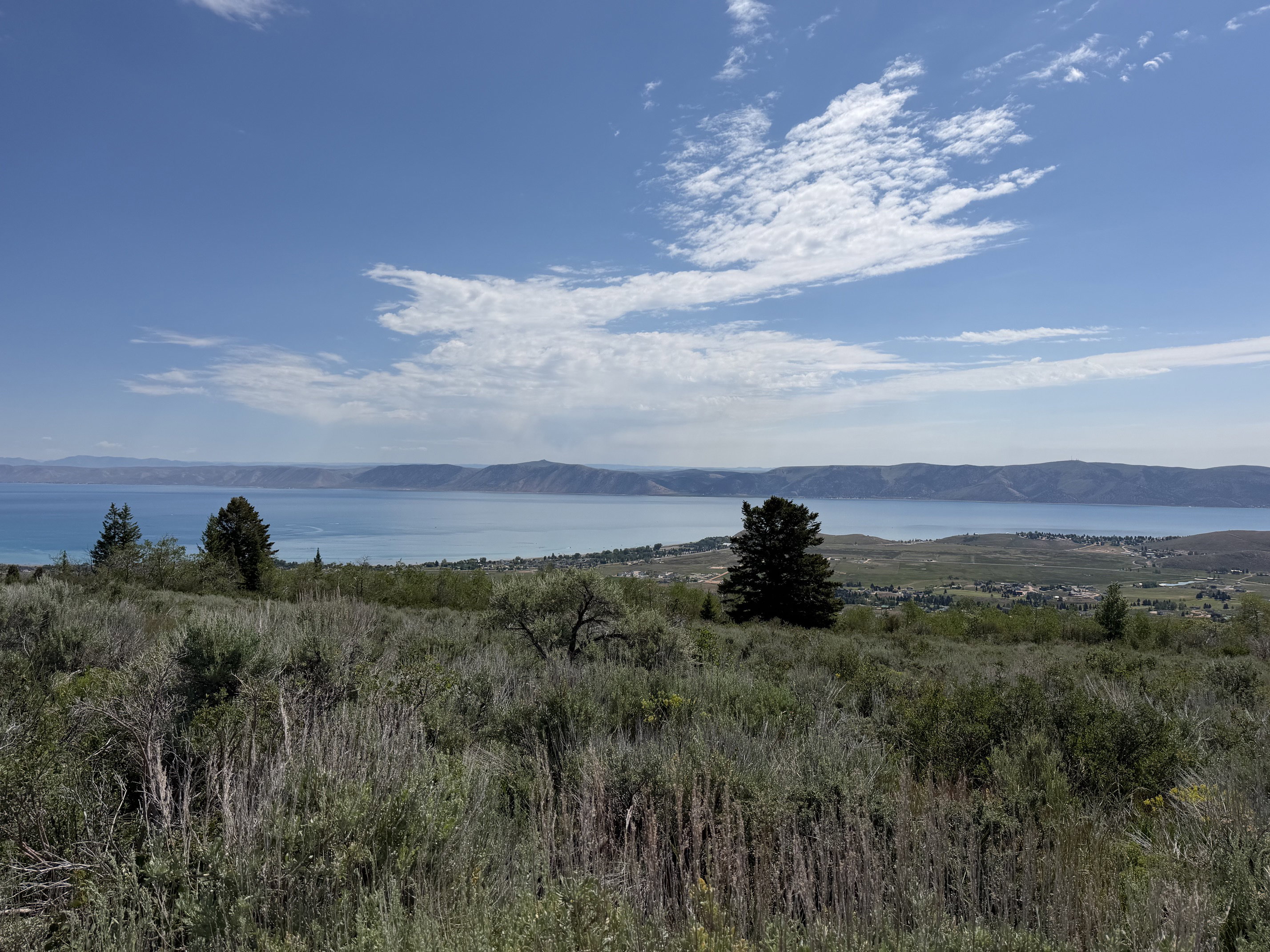 Expansive landscape featuring distant water and mountains under a clear sky