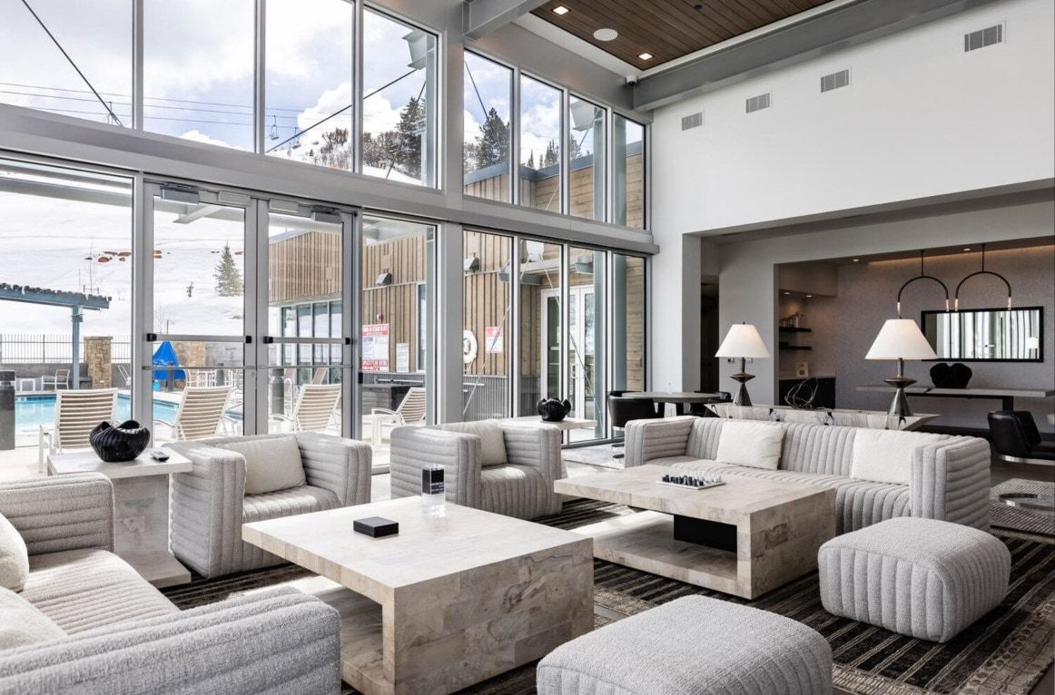 Spacious common area featuring a soaring ceiling, floor-to-ceiling windows, and a wood-finish ceiling accent