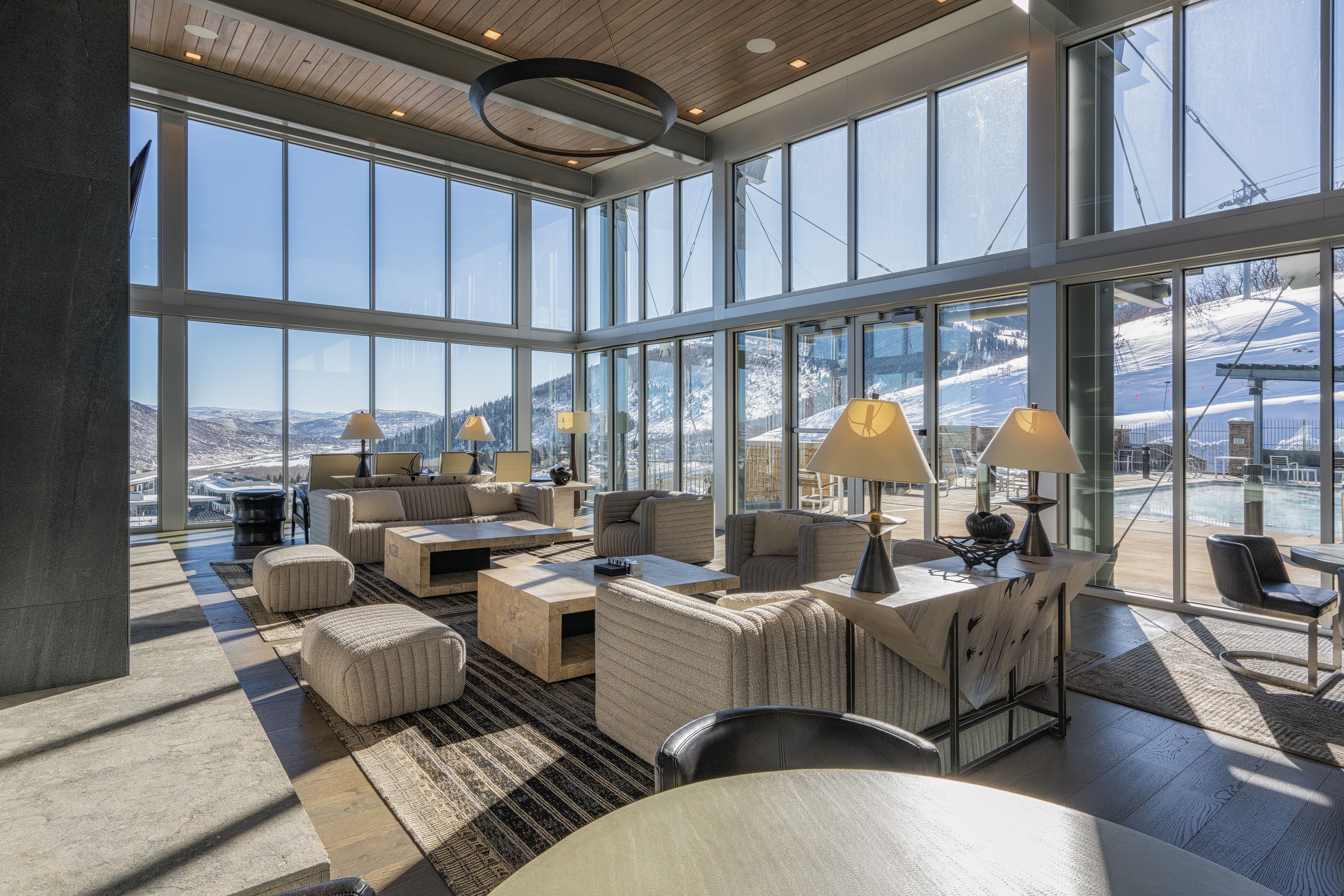 Great room featuring a wall of floor-to-ceiling windows, wood-finish ceiling, and a large circular chandelier