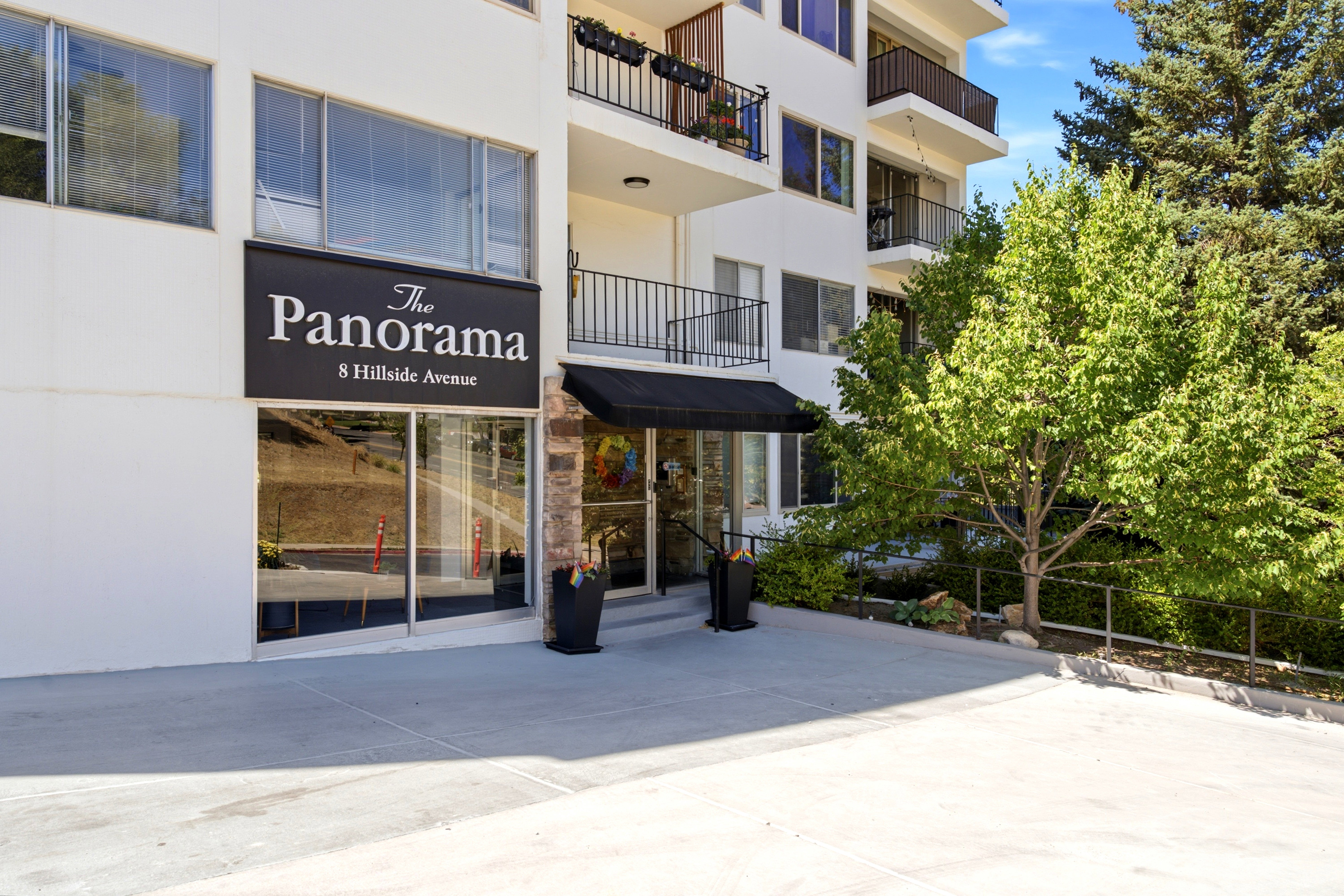 Contemporary multi-story building featuring white exterior siding and dark accents