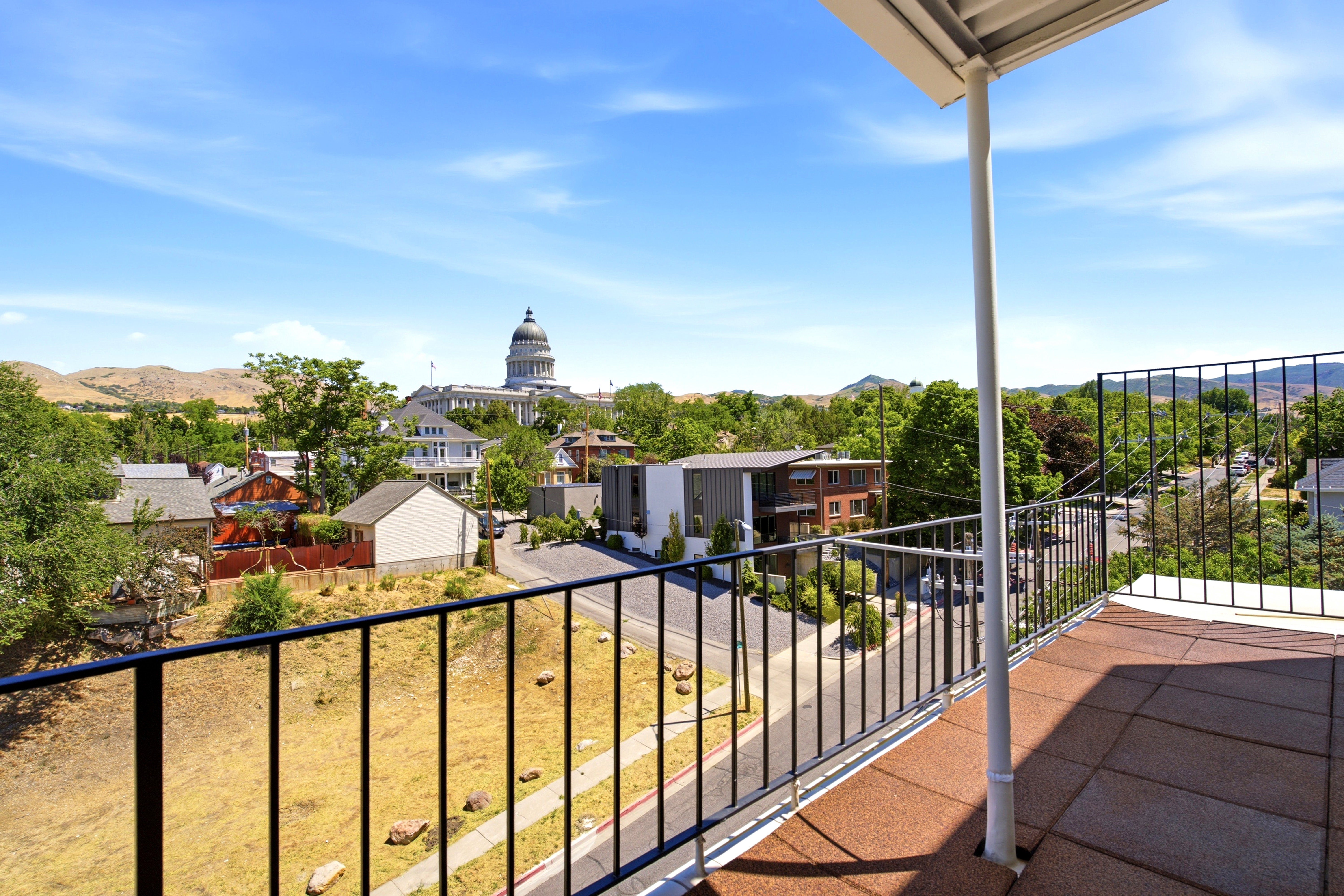 Expansive rooftop balcony featuring a durable tile surface and metal railing