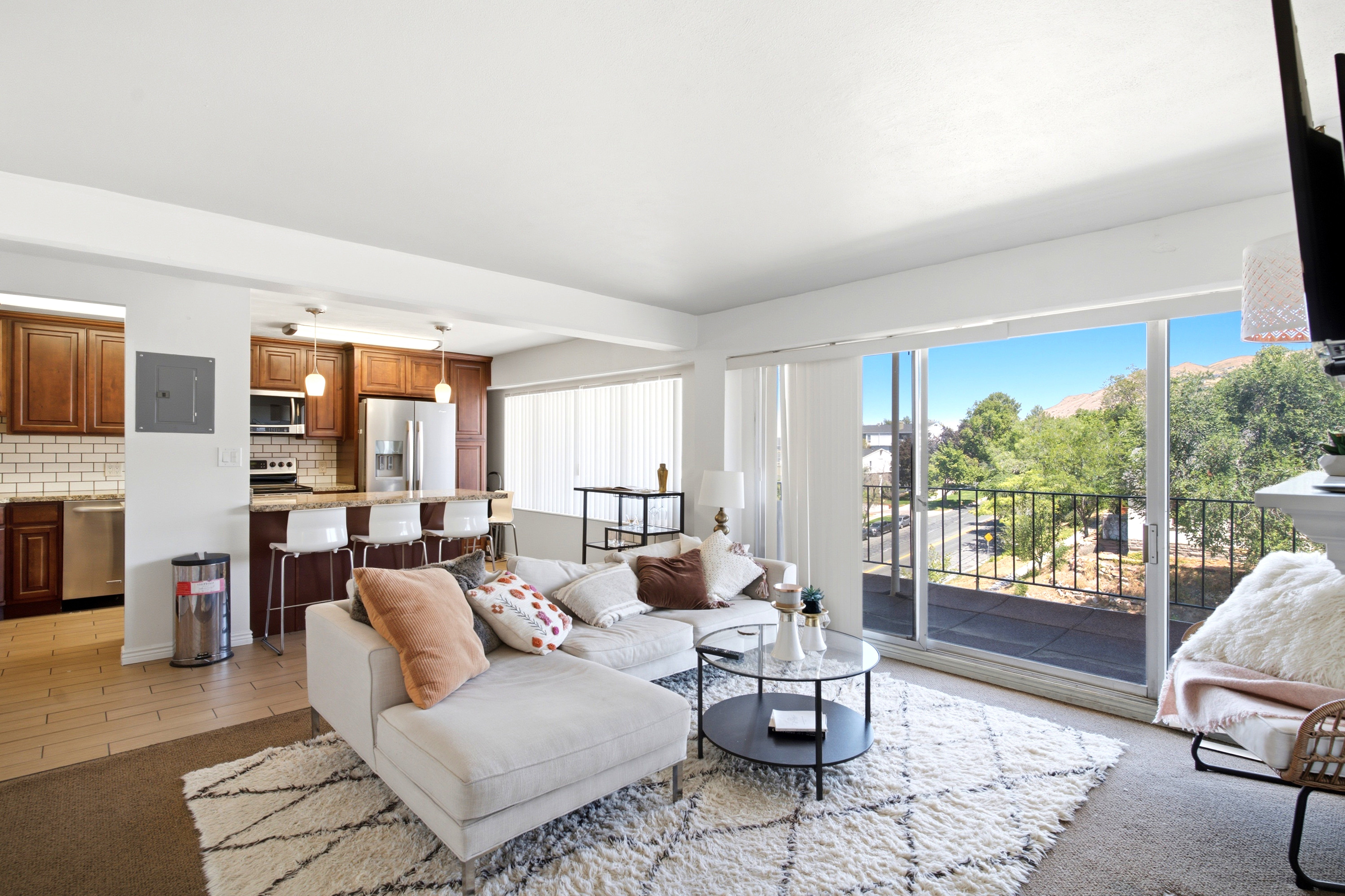 Open-concept living space featuring a full kitchen with dark wood cabinetry, stainless steel appliances, and a breakfast bar