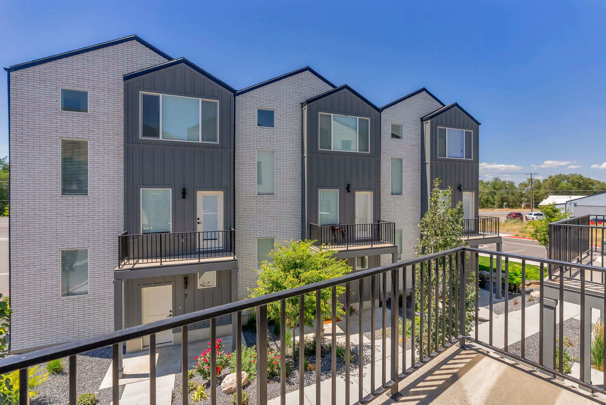Contemporary townhome exterior featuring light-colored brick and dark vertical siding