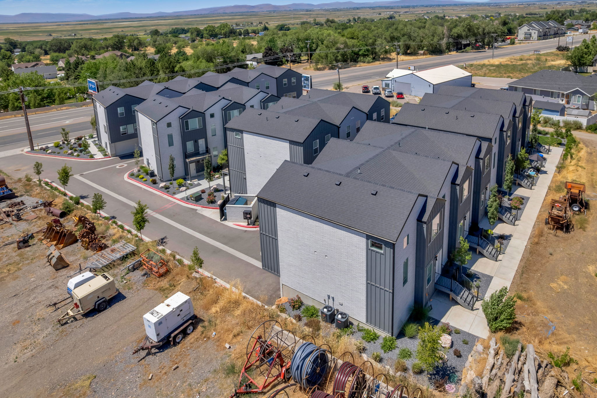 Contemporary townhome exteriors featuring multi-toned siding, dark roofs, and individual entrances