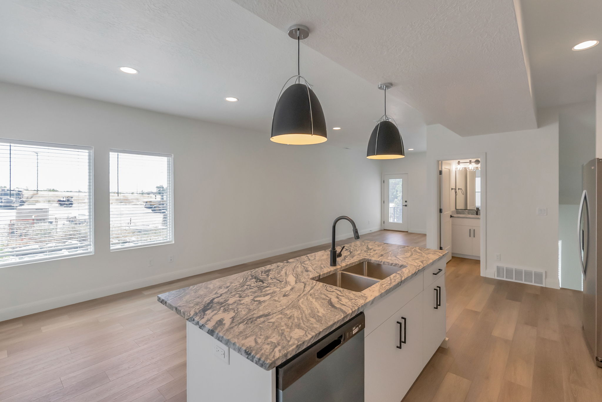 Central kitchen island with a patterned countertop, dual basin sink, and matte black faucet