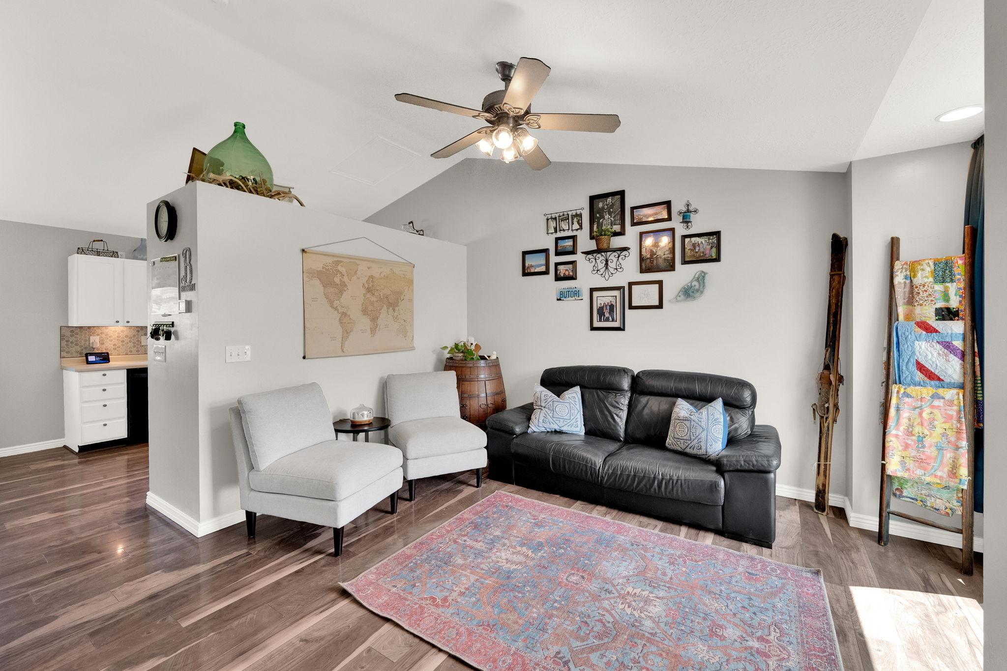 Spacious living area featuring vaulted ceilings with a ceiling fan, recessed lighting, and wood-finish flooring