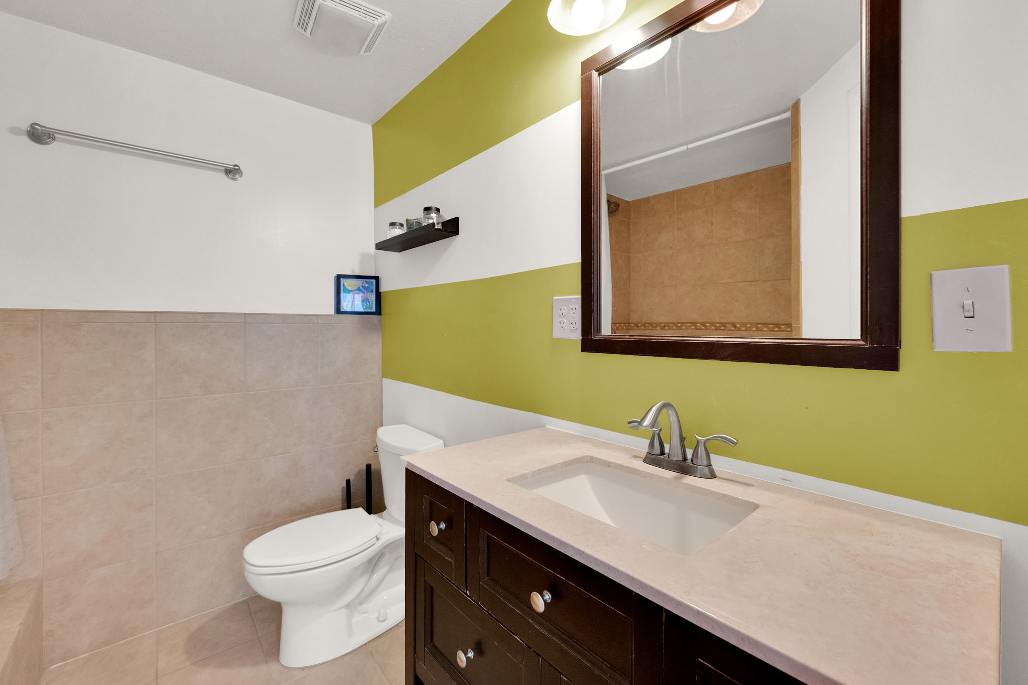 Vanity featuring a built-in sink, brushed nickel faucet, and wood-finish cabinetry with decorative pulls