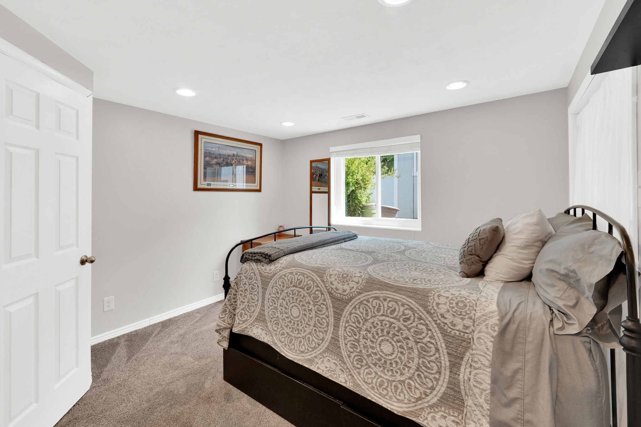 Windowed room featuring recessed lighting, a white paneled door, light gray walls, and gray carpet flooring