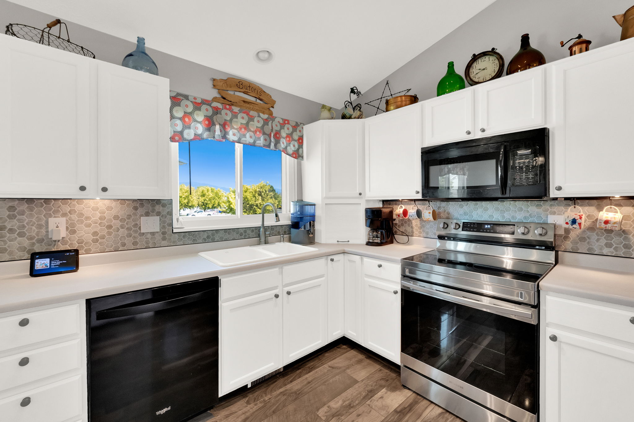 Kitchen featuring white cabinetry with dark hardware, a mosaic tile backsplash, and light countertops