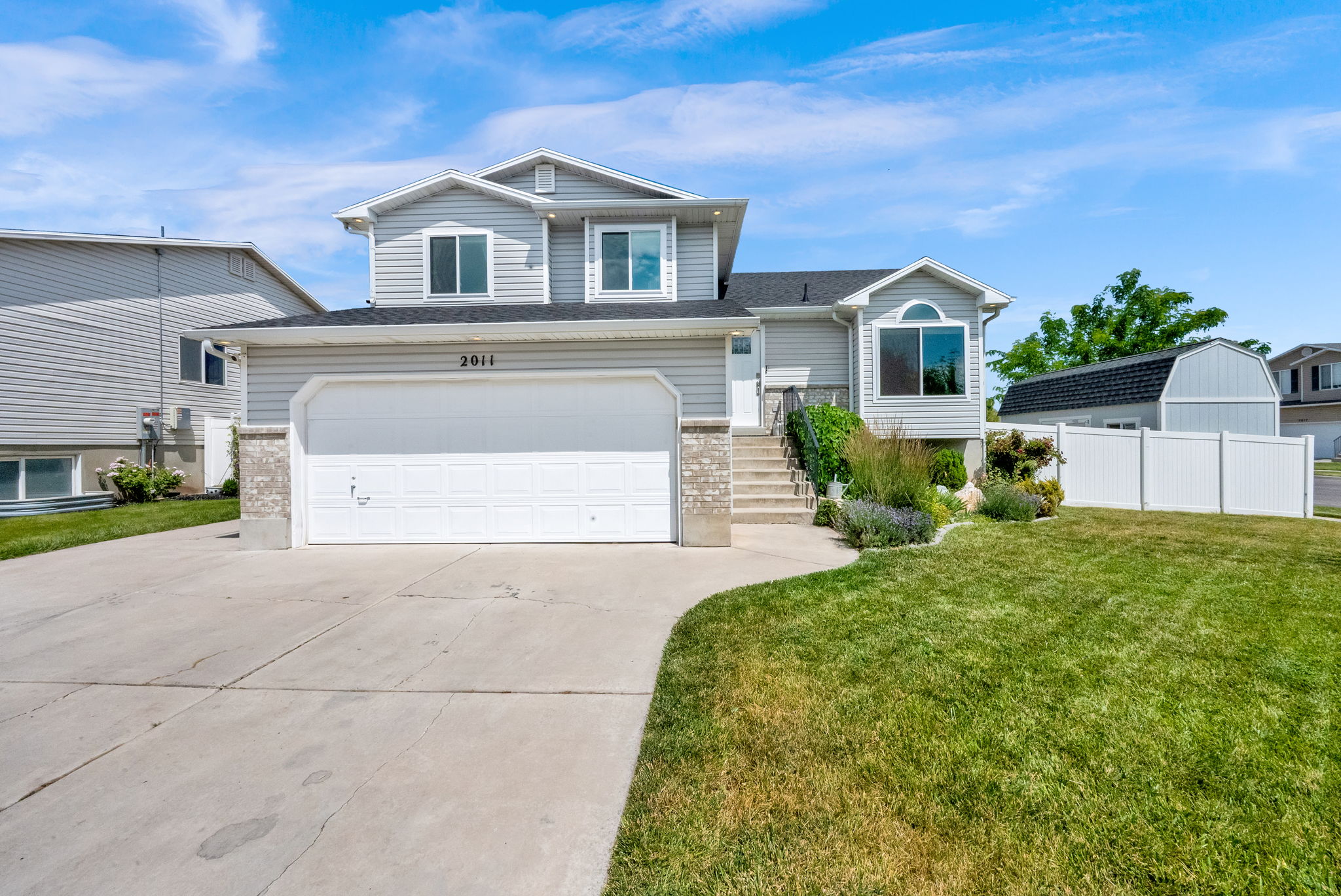 Two-story home with light gray siding and a two-car garage