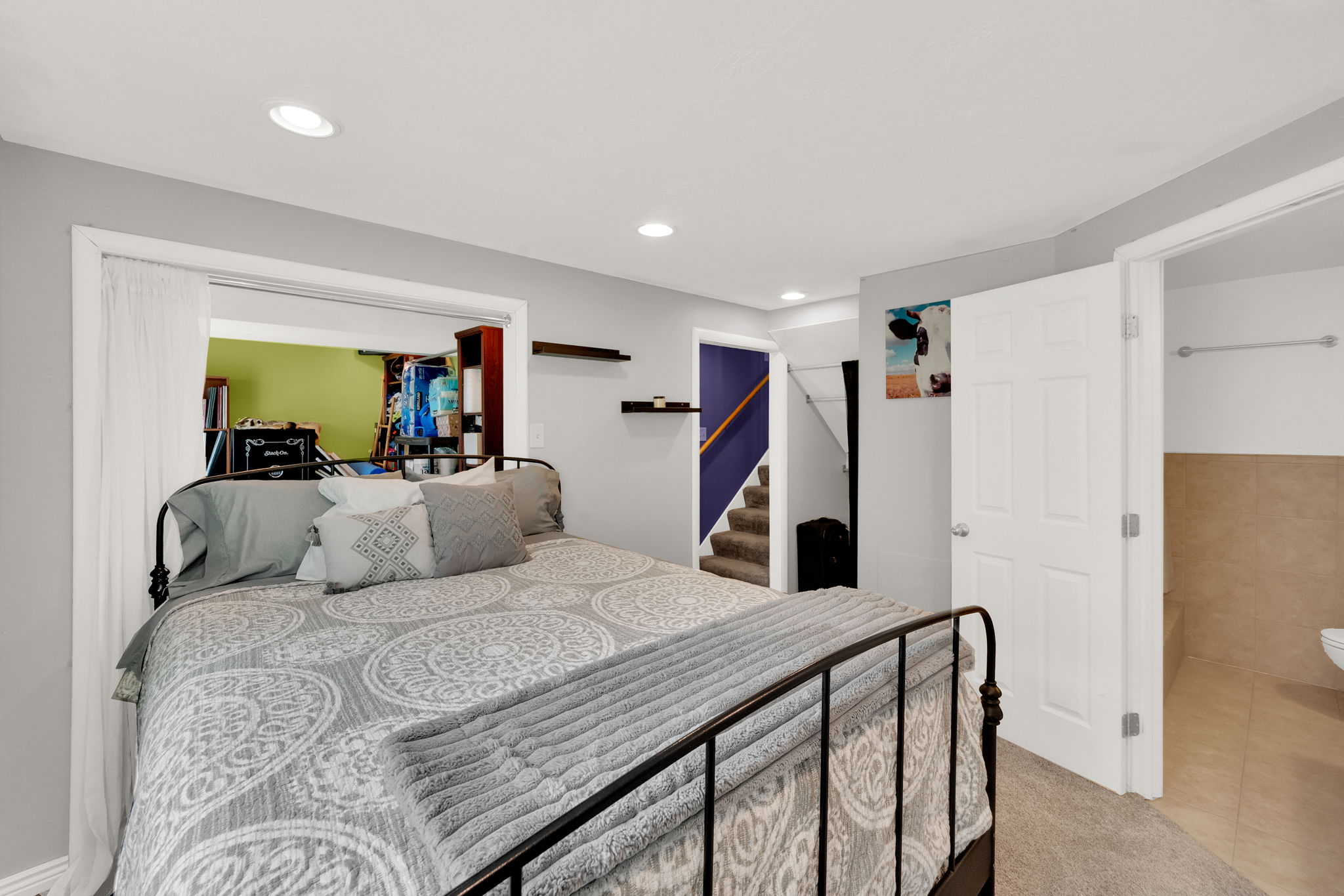 Carpeted bedroom featuring recessed lighting, a wide doorway opening, a white paneled door, and a partially visible tiled room
