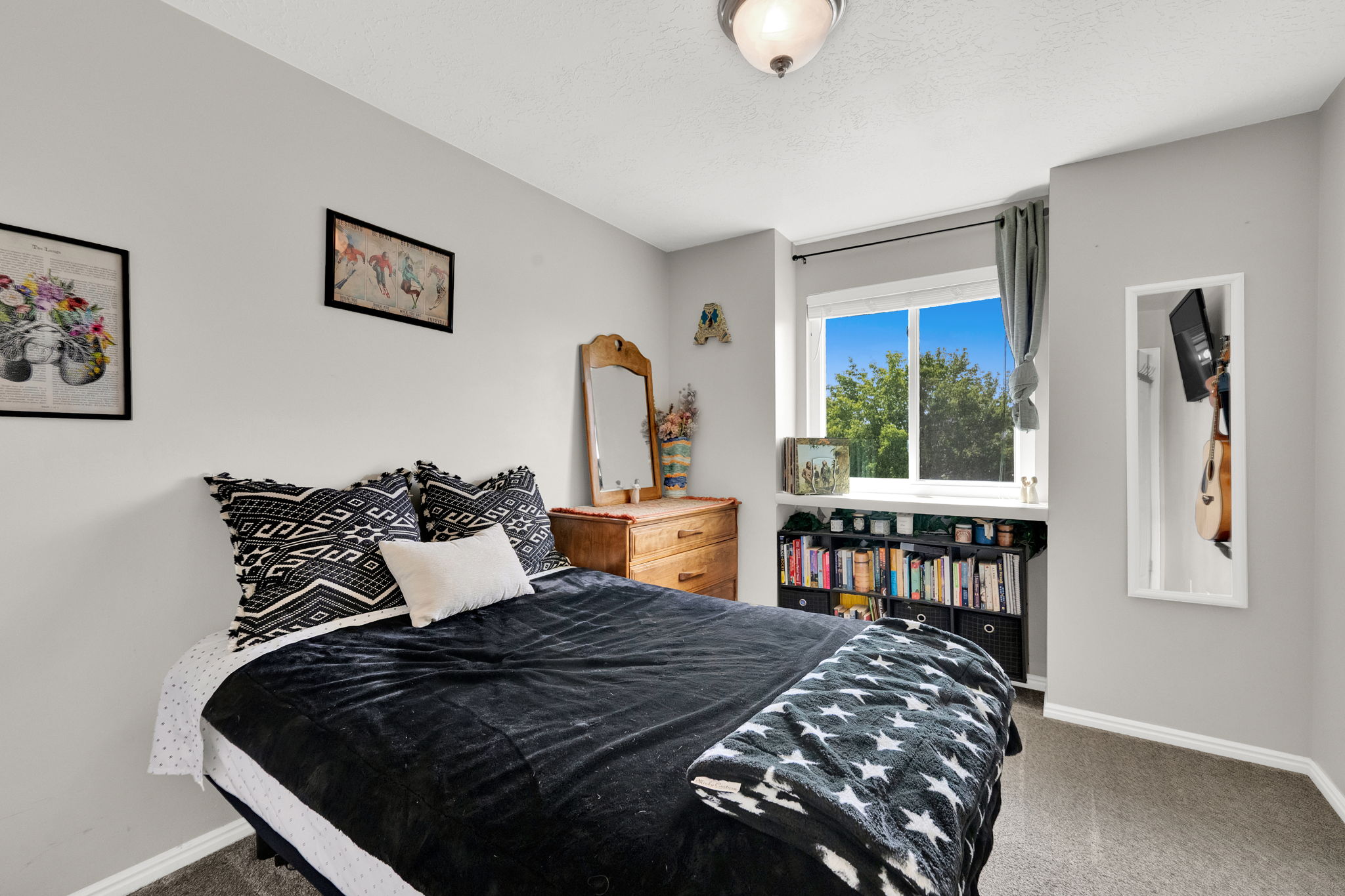 Carpeted bedroom featuring a large window, a built-in window shelf, and an overhead flush mount light fixture