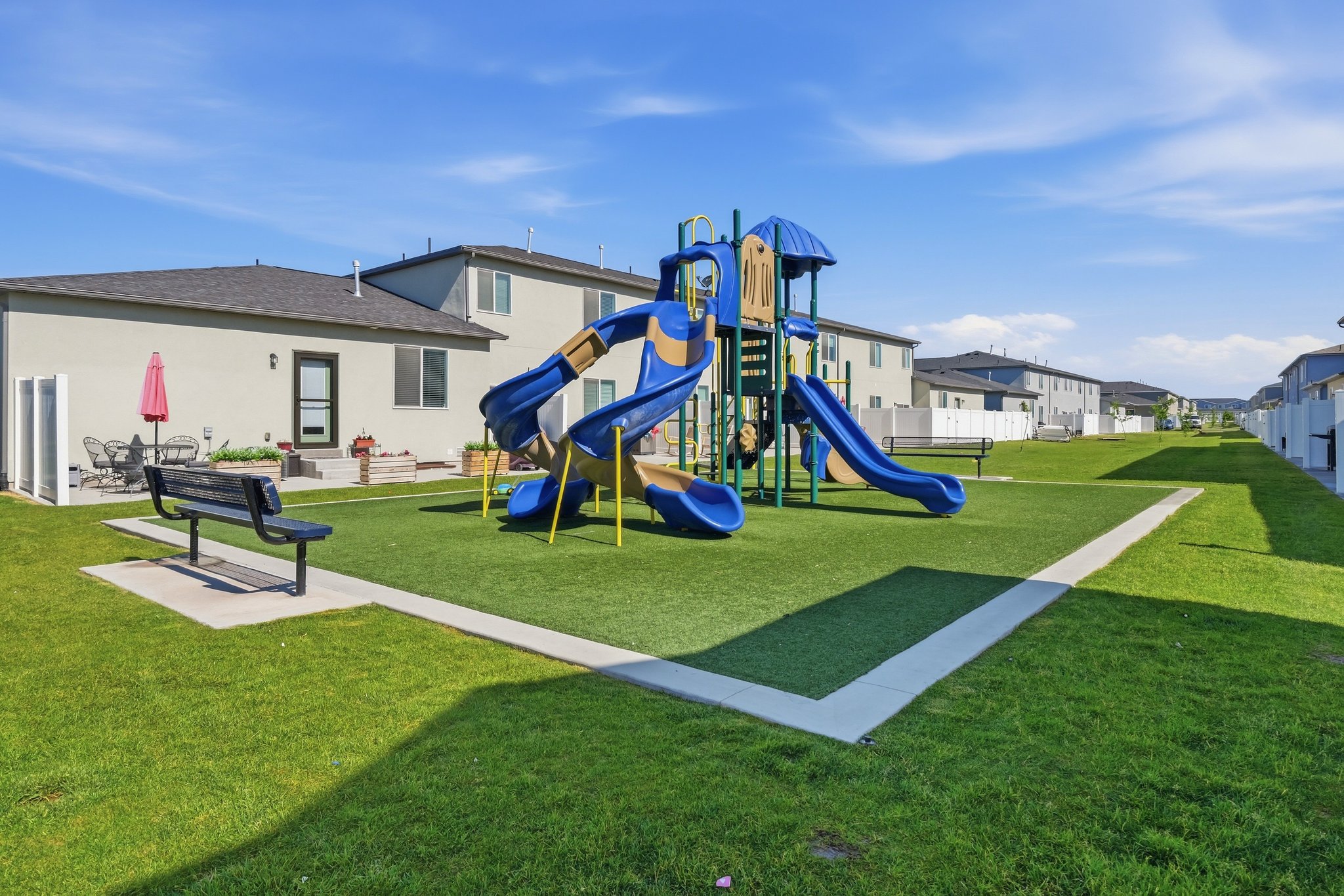 Central playground area featuring blue and yellow slides, a climbing wall, and platforms
