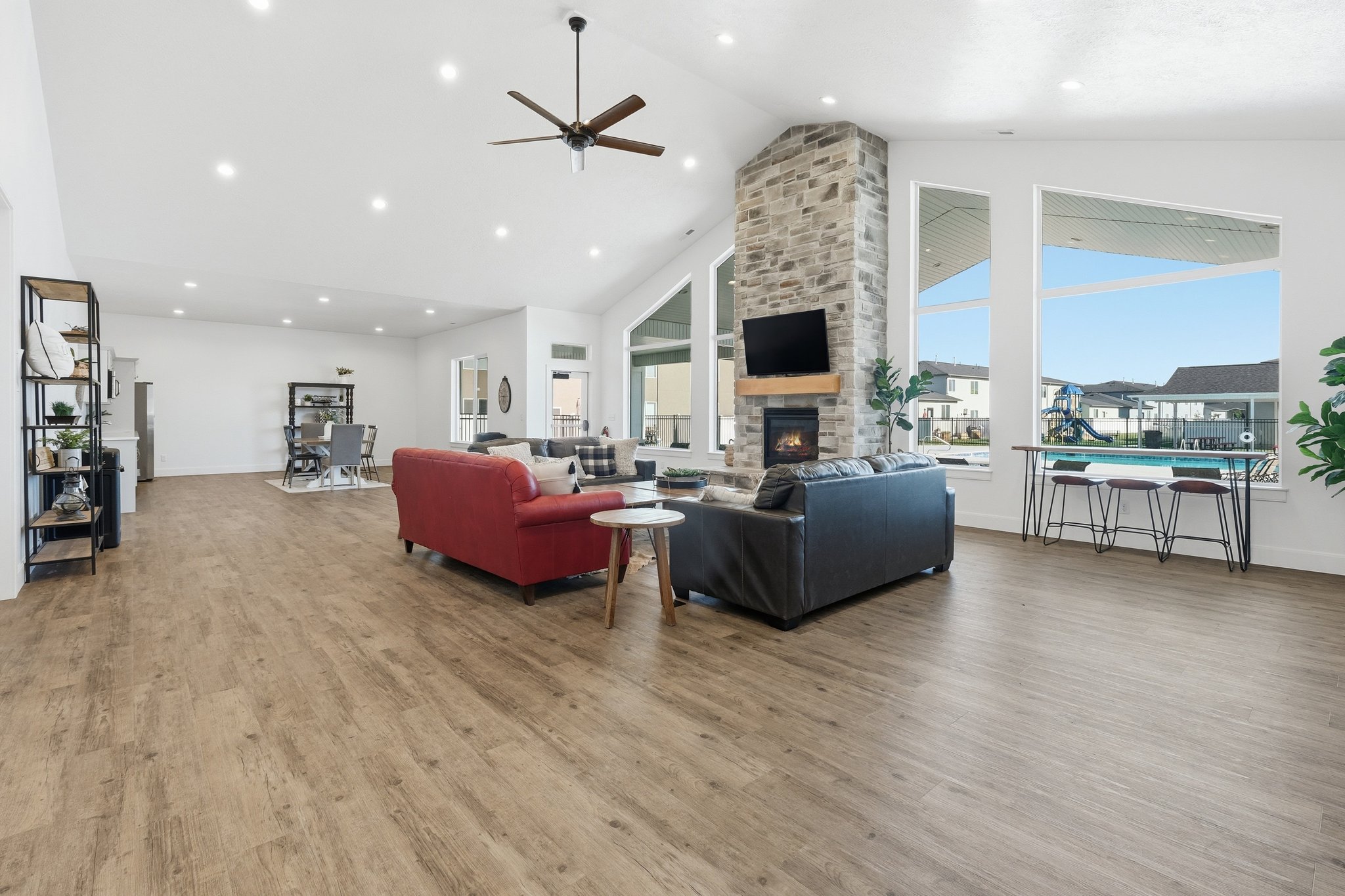 Expansive open-concept living area featuring a vaulted ceiling and wood-finish flooring throughout