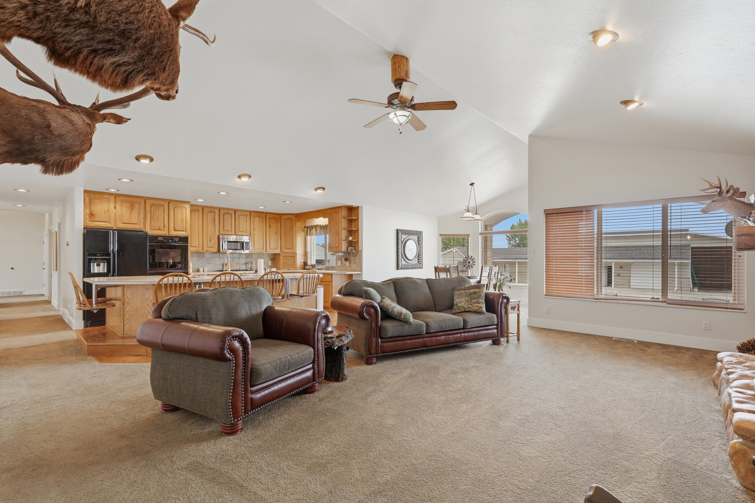 Expansive living area featuring vaulted ceilings, recessed lighting, and large windows