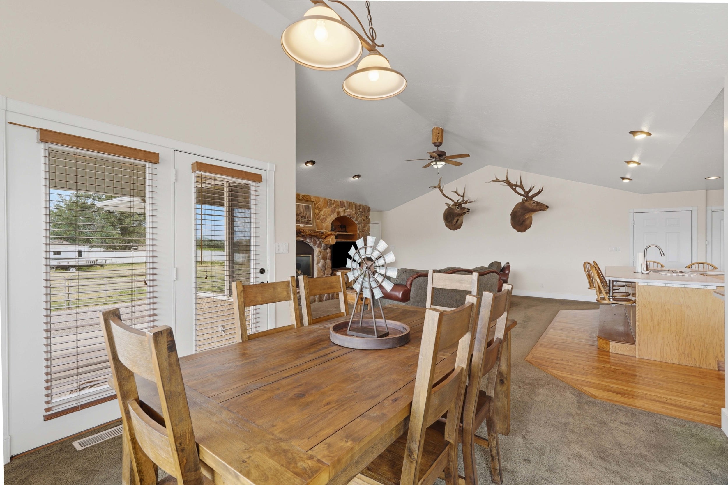 Vaulted ceilings with recessed lighting, an open-concept layout, and a stone fireplace
