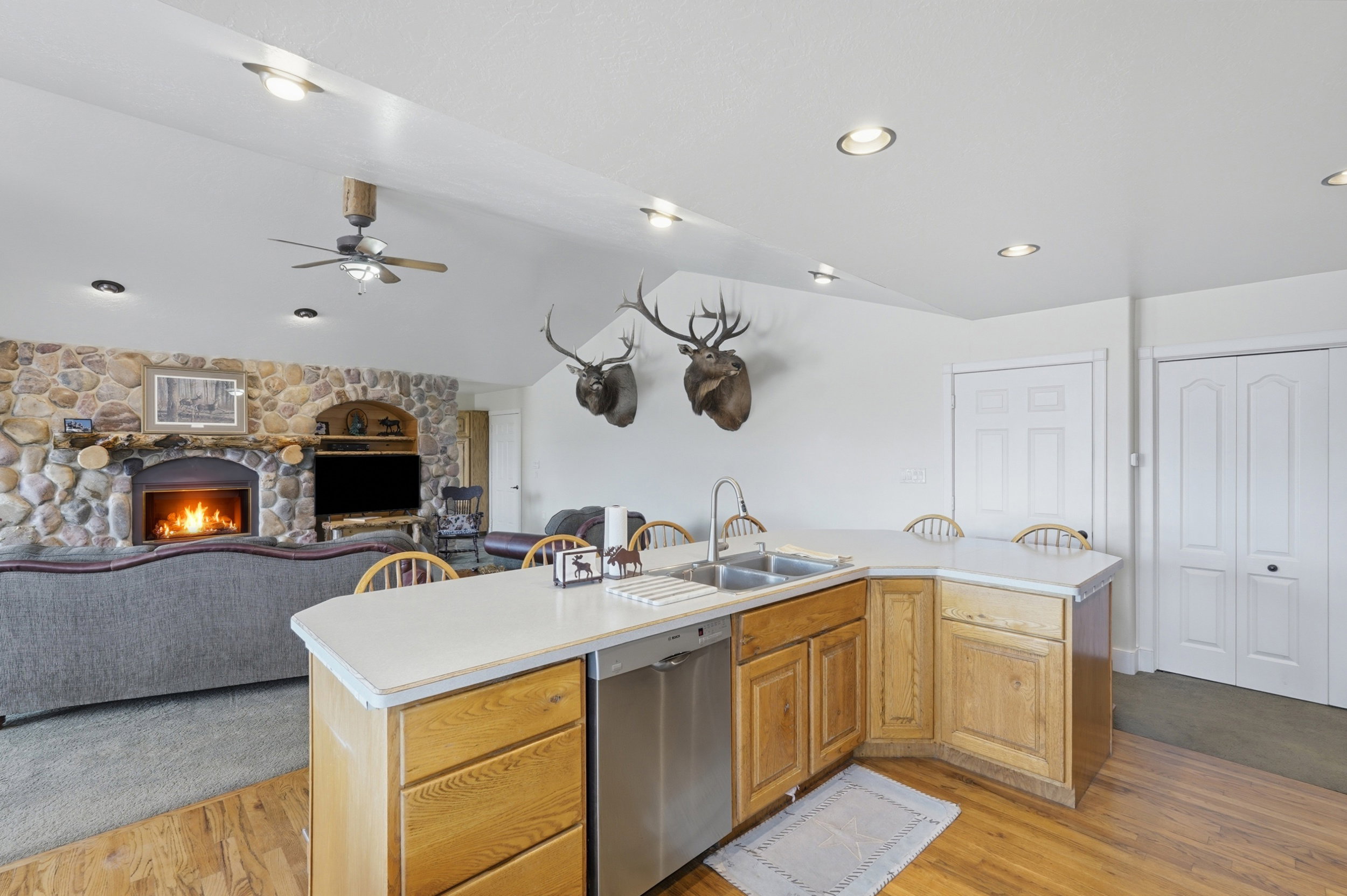 Kitchen island with wood-finish cabinetry, a dual basin sink, and a stainless steel dishwasher