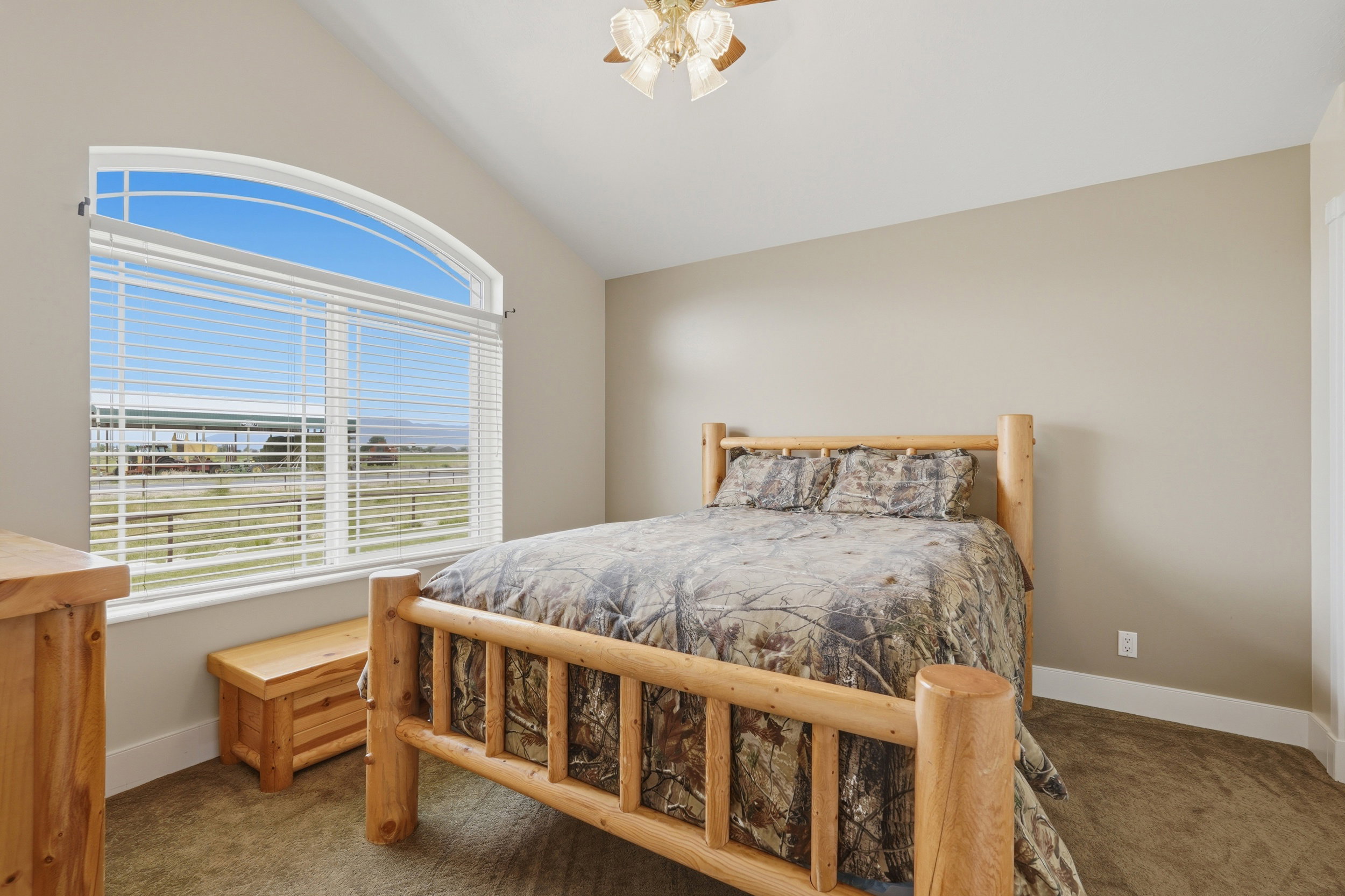 Room featuring a vaulted ceiling and an arched window