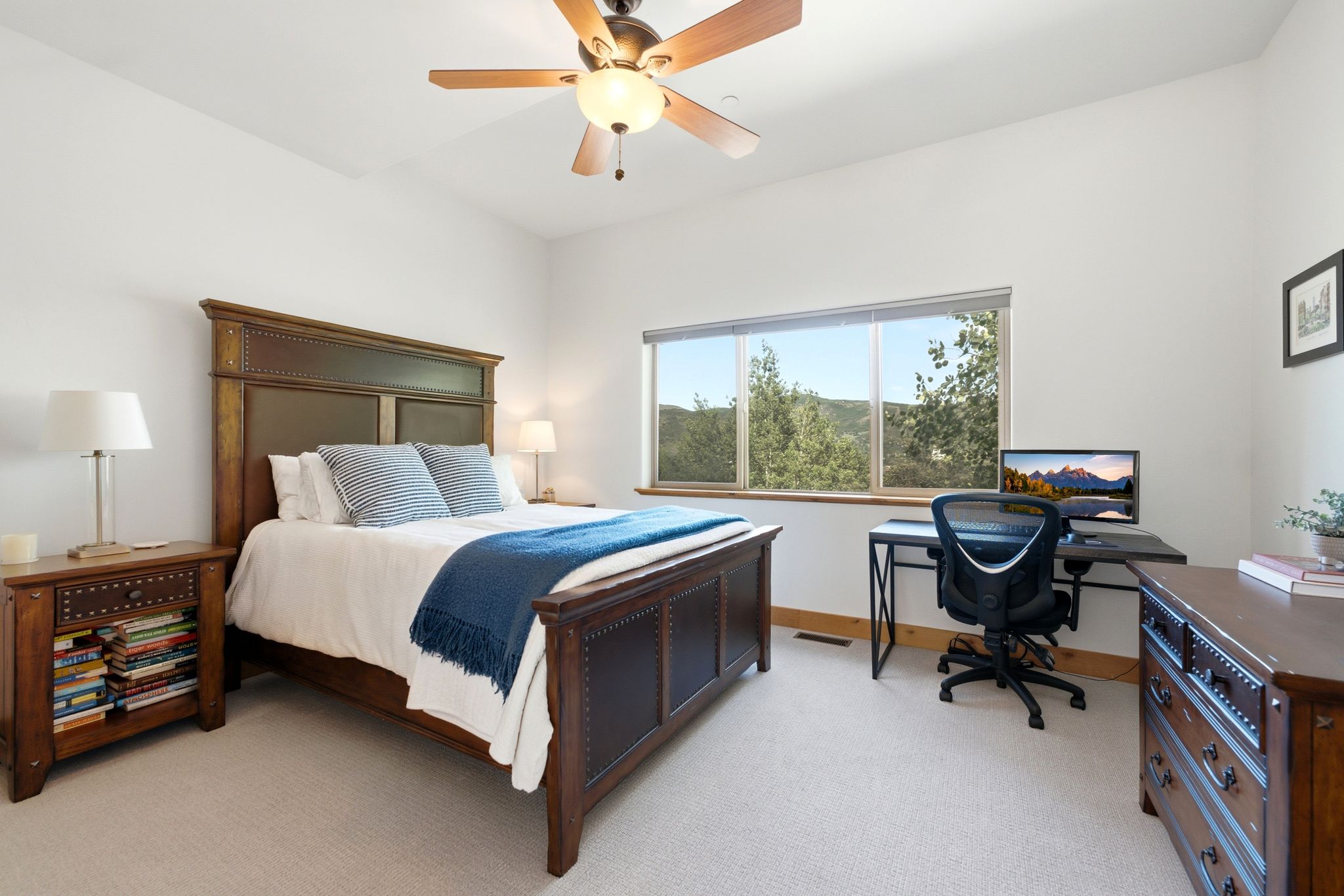 Bright bedroom featuring a wide window with outdoor scenery, recessed lighting, and a ceiling fan with integrated illumination