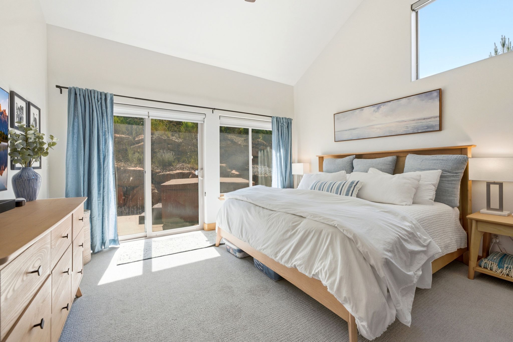 Vaulted ceiling room featuring light-colored carpeting and white walls