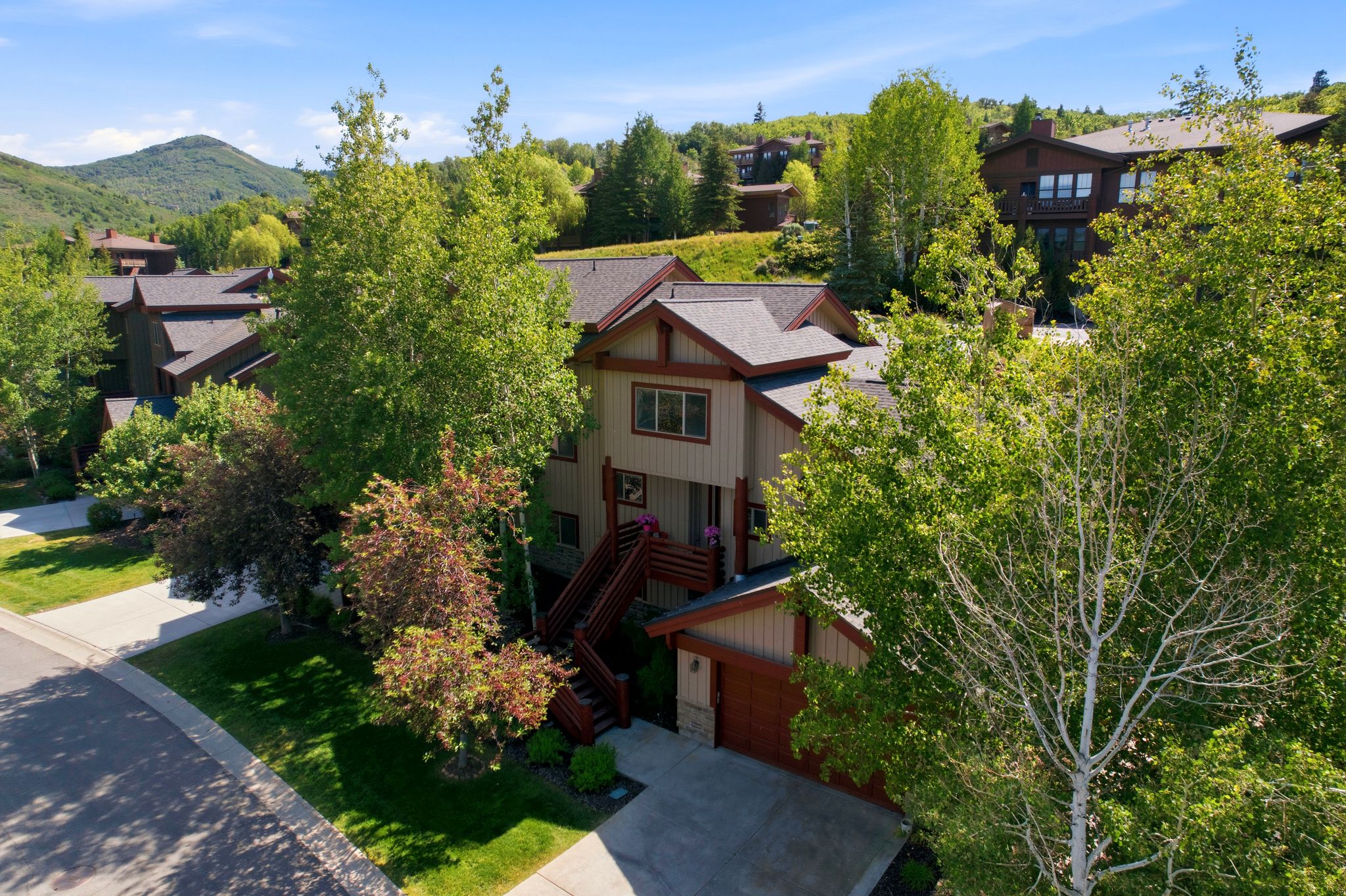 Multi-level residence featuring a two-car garage, pitched roofline, and an exterior balcony