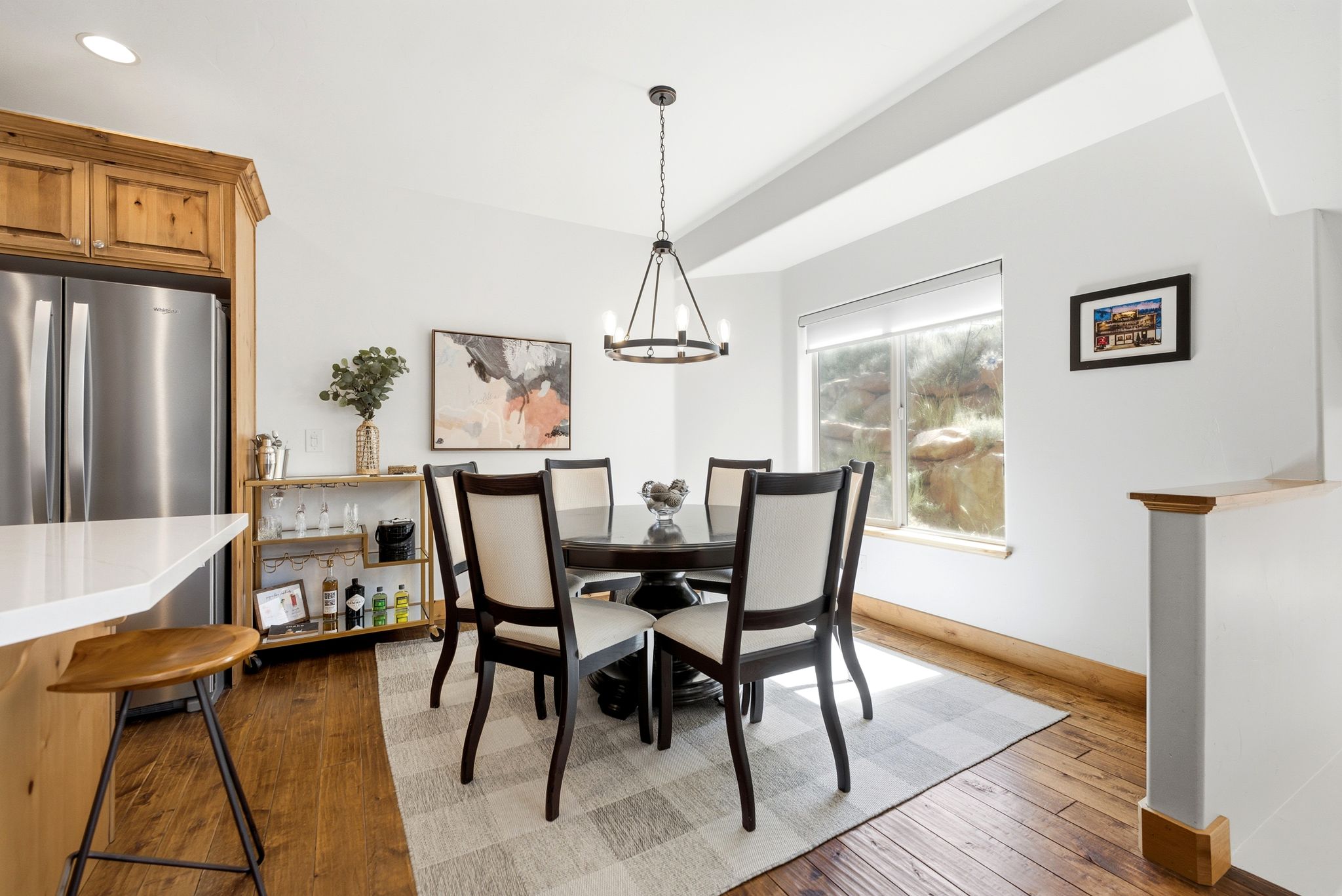 Dining area featuring wood-finish flooring, a contemporary chandelier, and a large window
