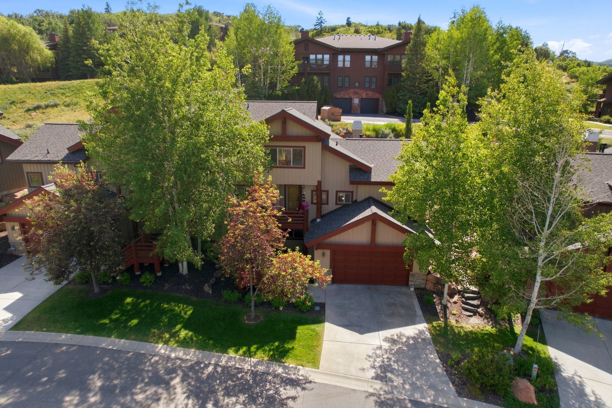 Contemporary multi-level residence featuring a two-car garage, pitched rooflines, and a stucco exterior with wood accents