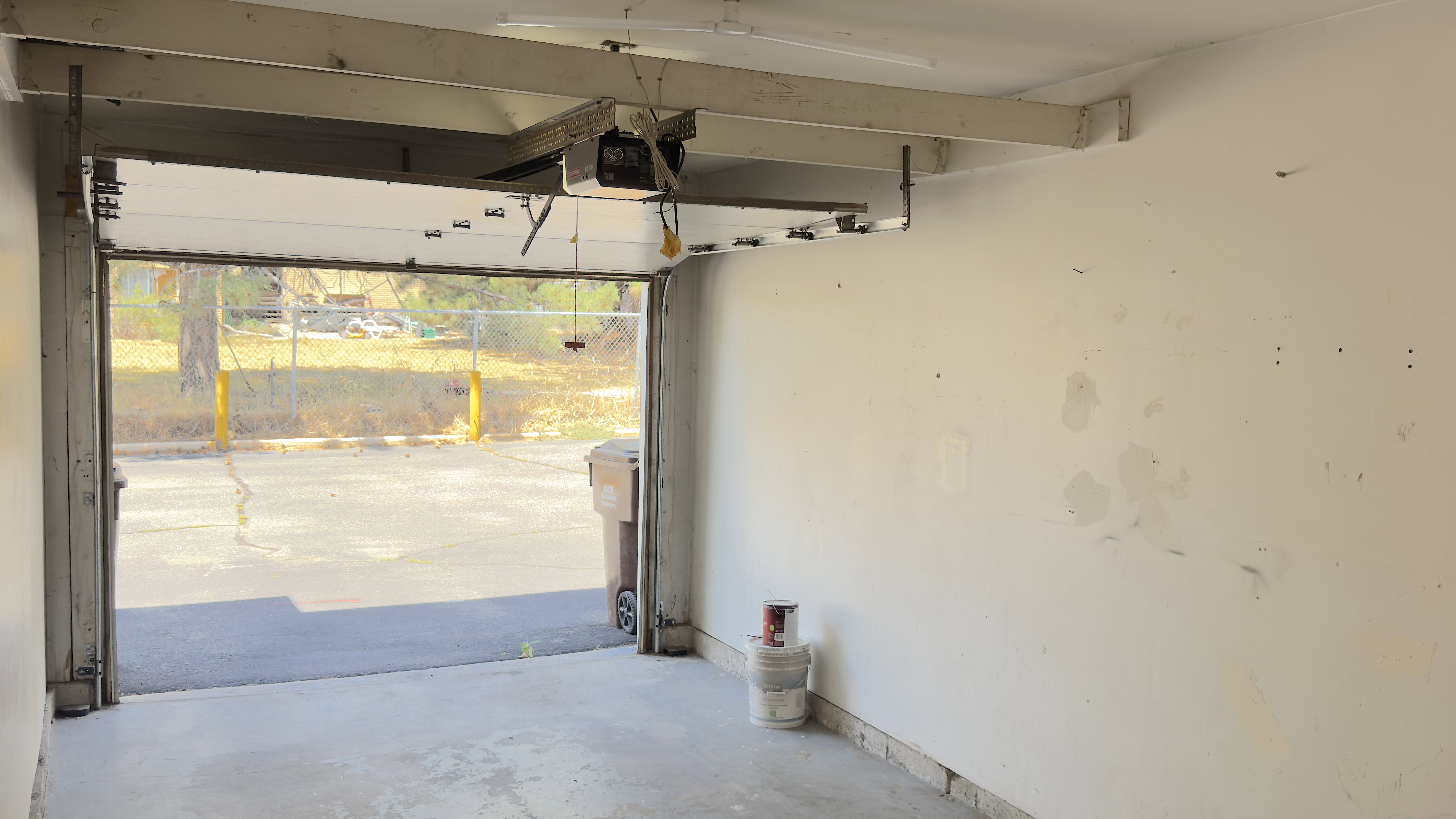 Garage featuring an automatic overhead door, concrete flooring.
