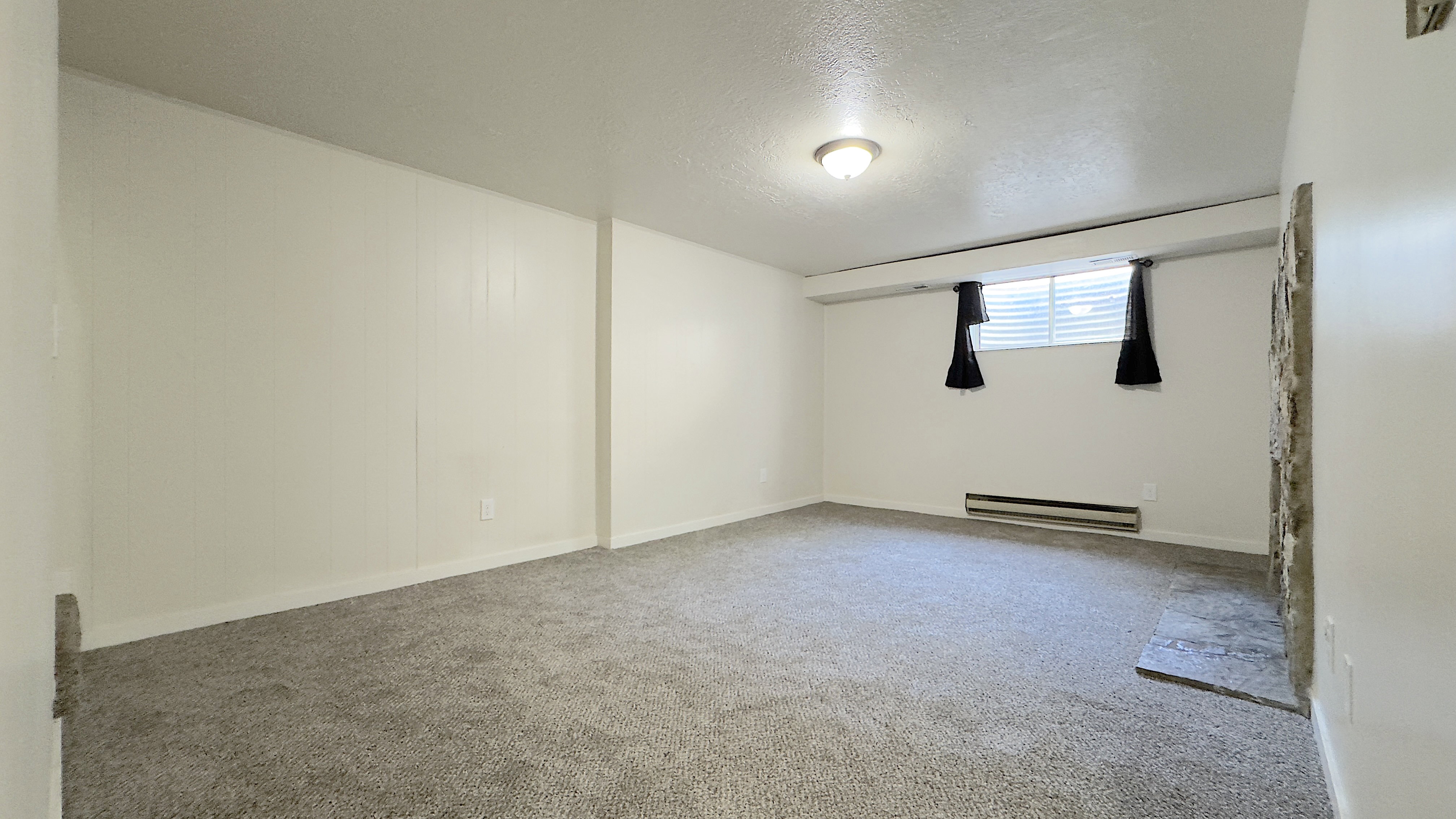 Spacious family room featuring a wood burning stone-clad fireplace and new carpet.