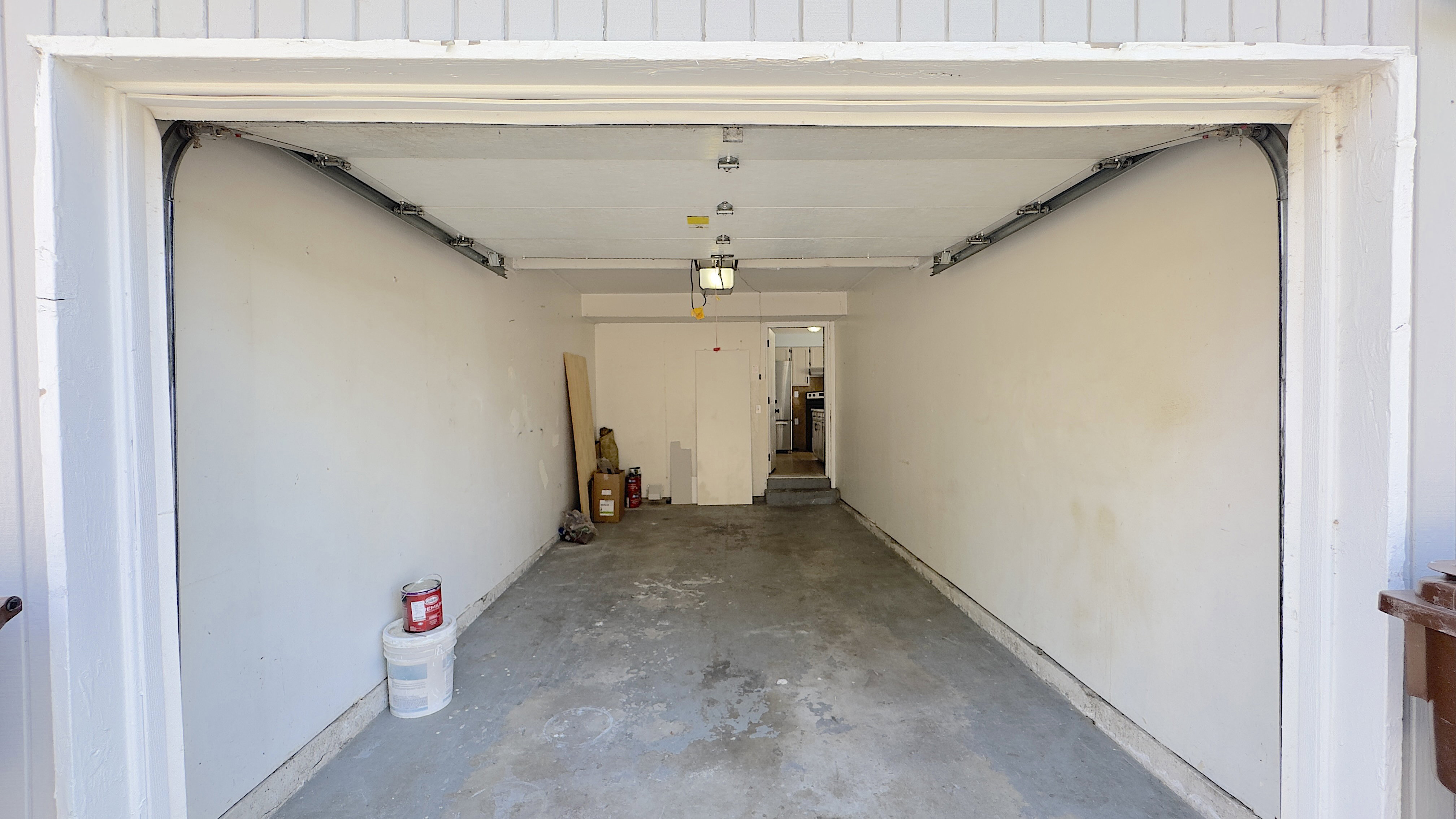 Spacious garage with concrete flooring, and overhead lighting.