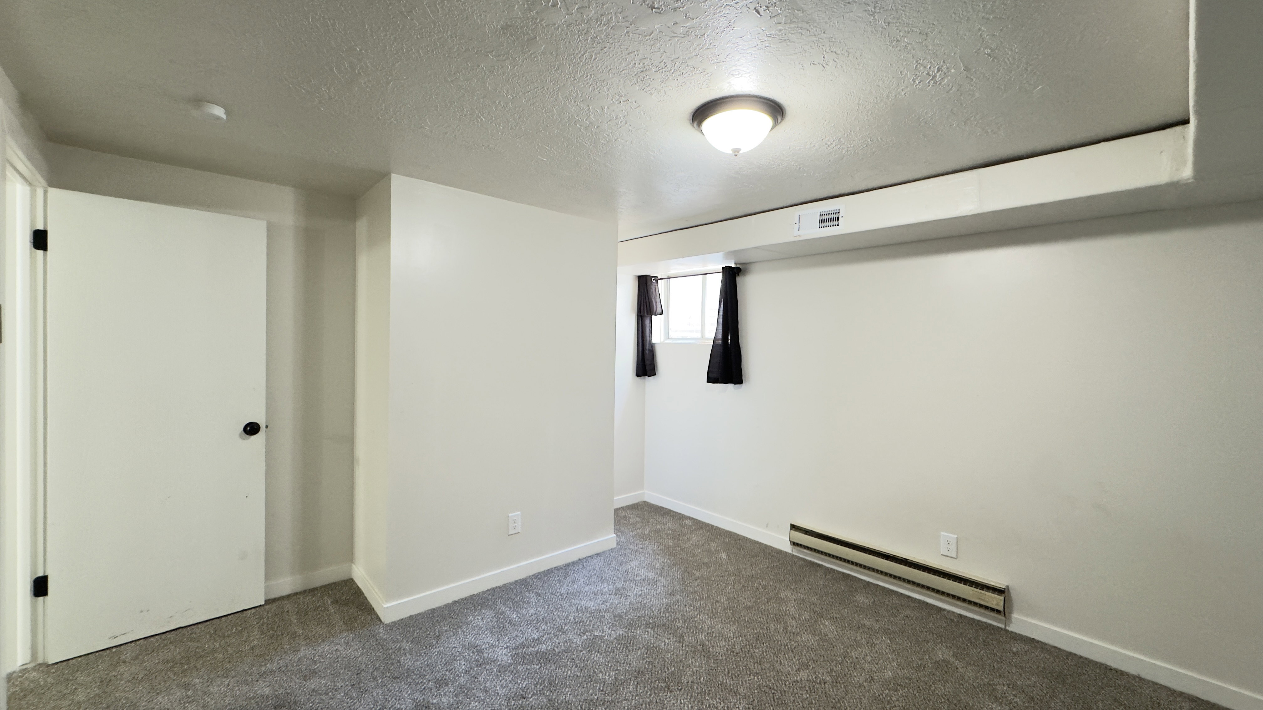 Basement, bedroom room featuring new carpet.
