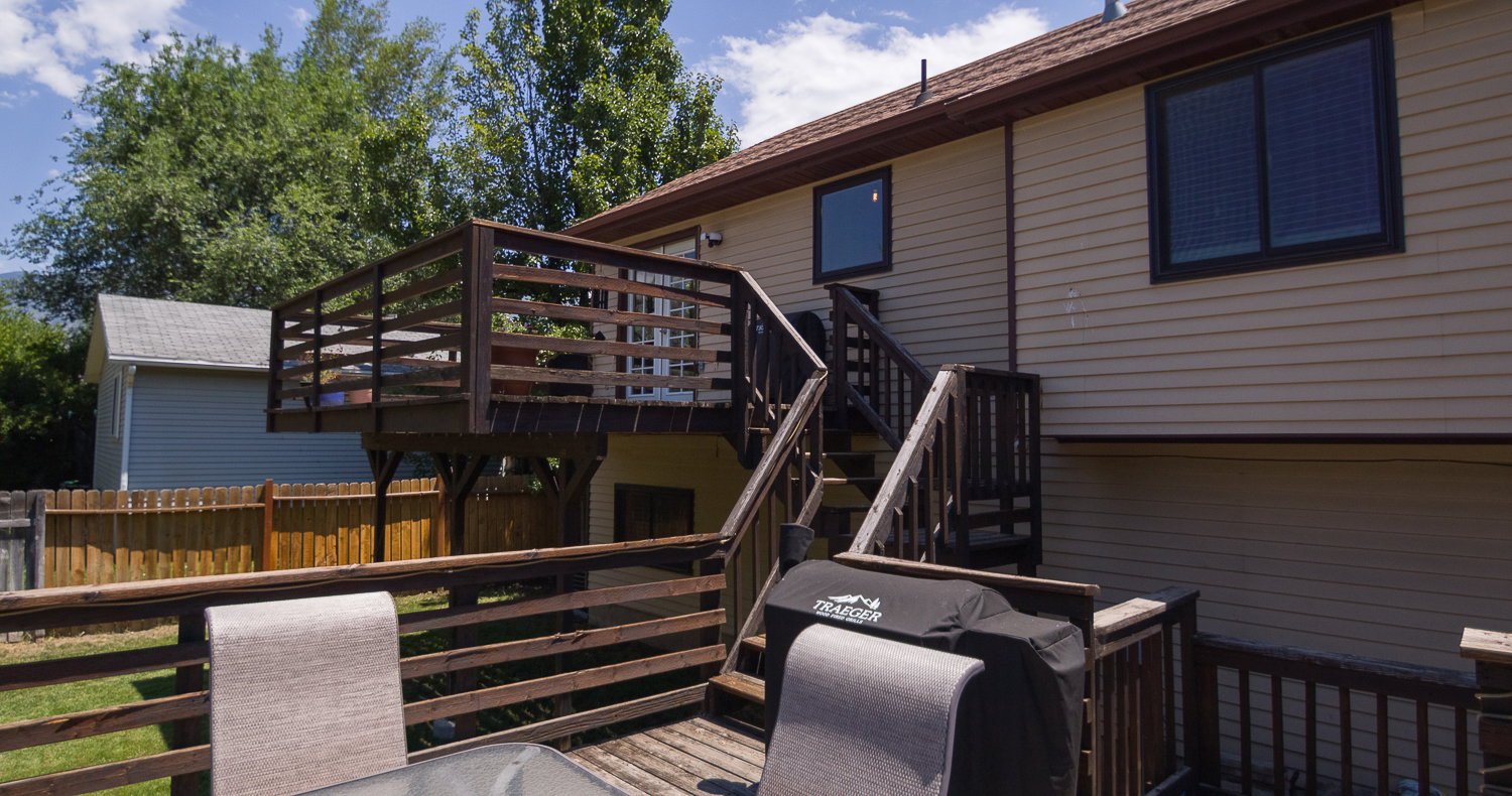 Multi-level wood deck featuring a railing system and stairs