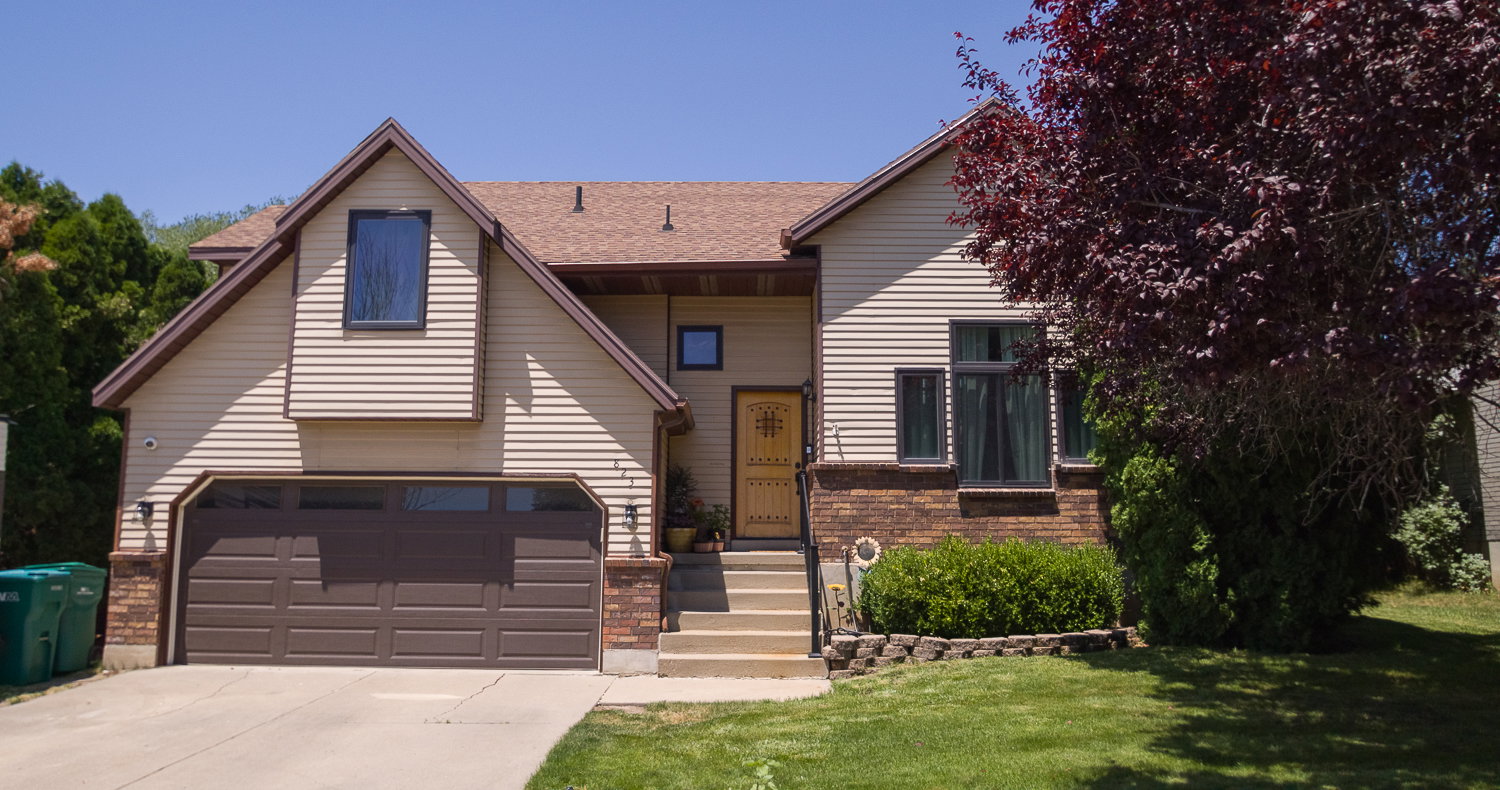 Siding exterior with brick accents and a brown asphalt shingle roof