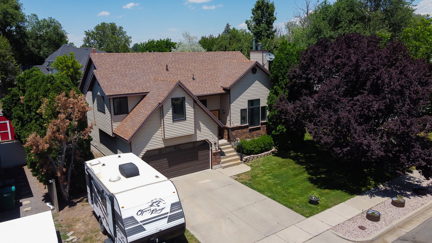 Split-level residence featuring a two-car garage with a wood-finish door