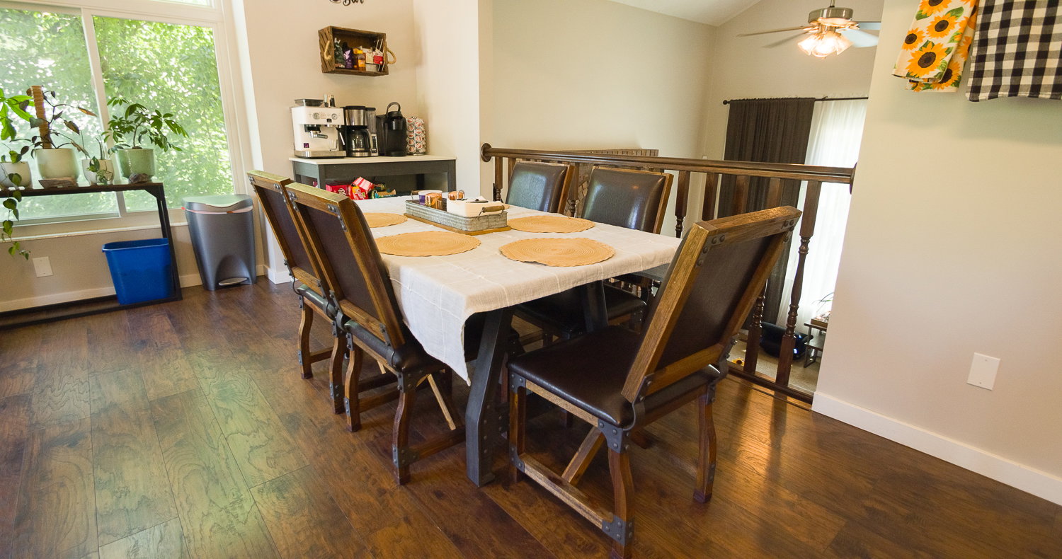 Wood-finish flooring throughout, featuring a dining area with a built-in coffee bar